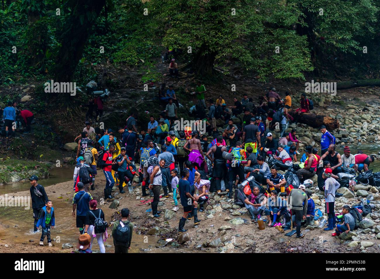 I migranti si fermano per una pausa prima di salire su un sentiero collinare fangoso nella giungla selvaggia e pericolosa del Darién Gap tra Colombia e Panamá. Foto Stock