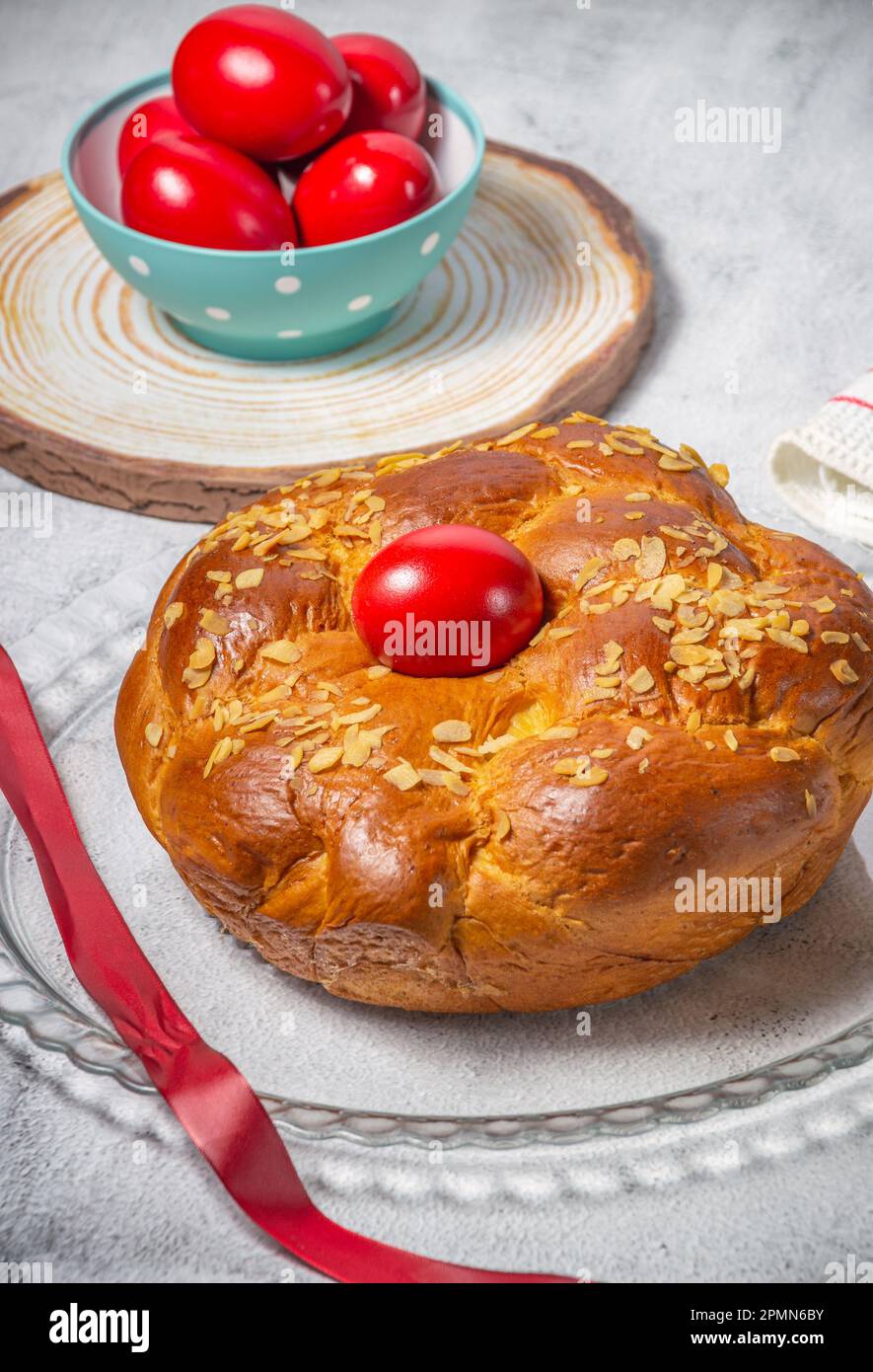 Pane tradizionale pasquale, toureki greco e uova rosse su un tavolo Foto Stock