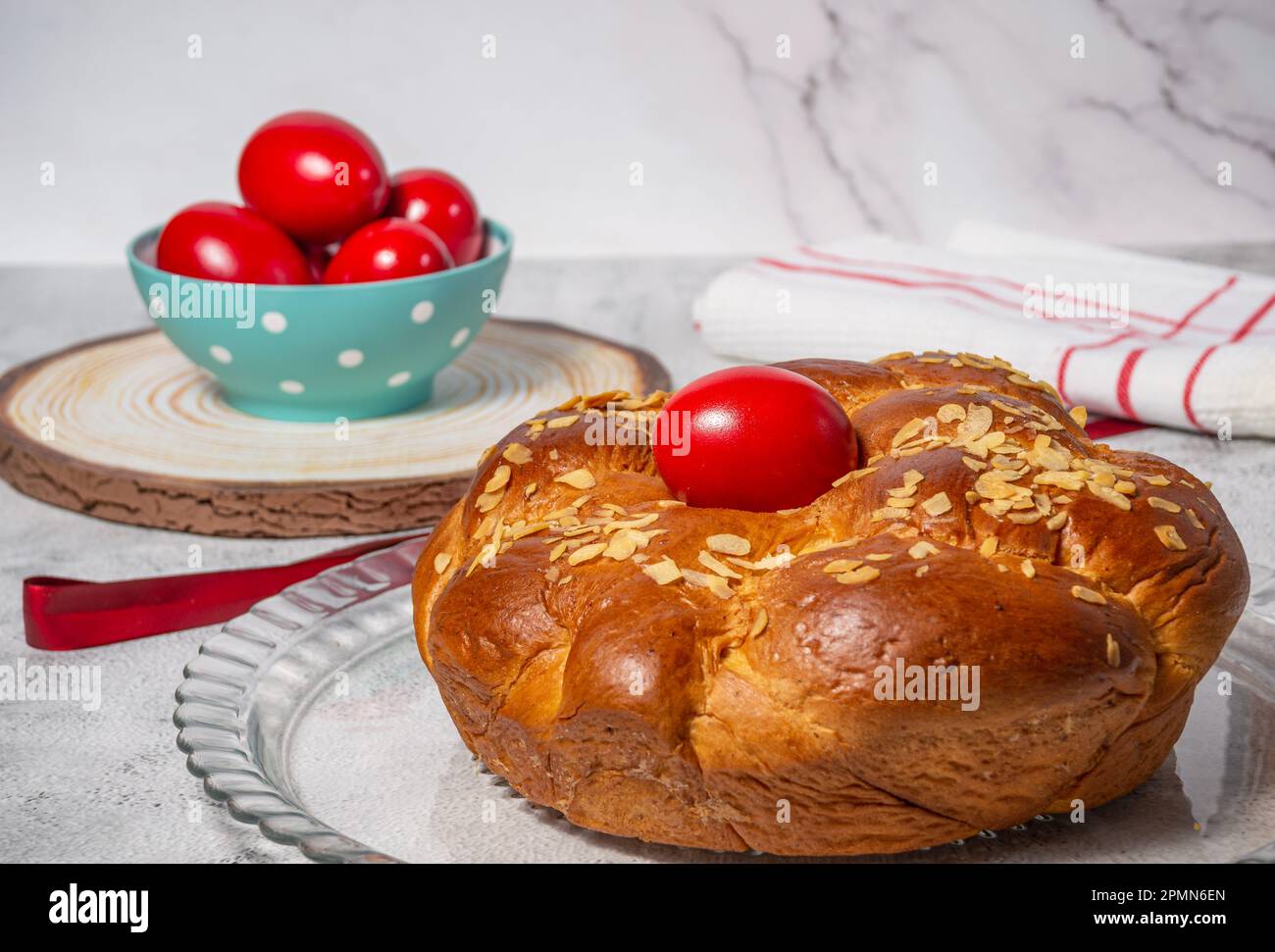 Pane tradizionale pasquale, toureki greco e uova rosse su un tavolo Foto Stock