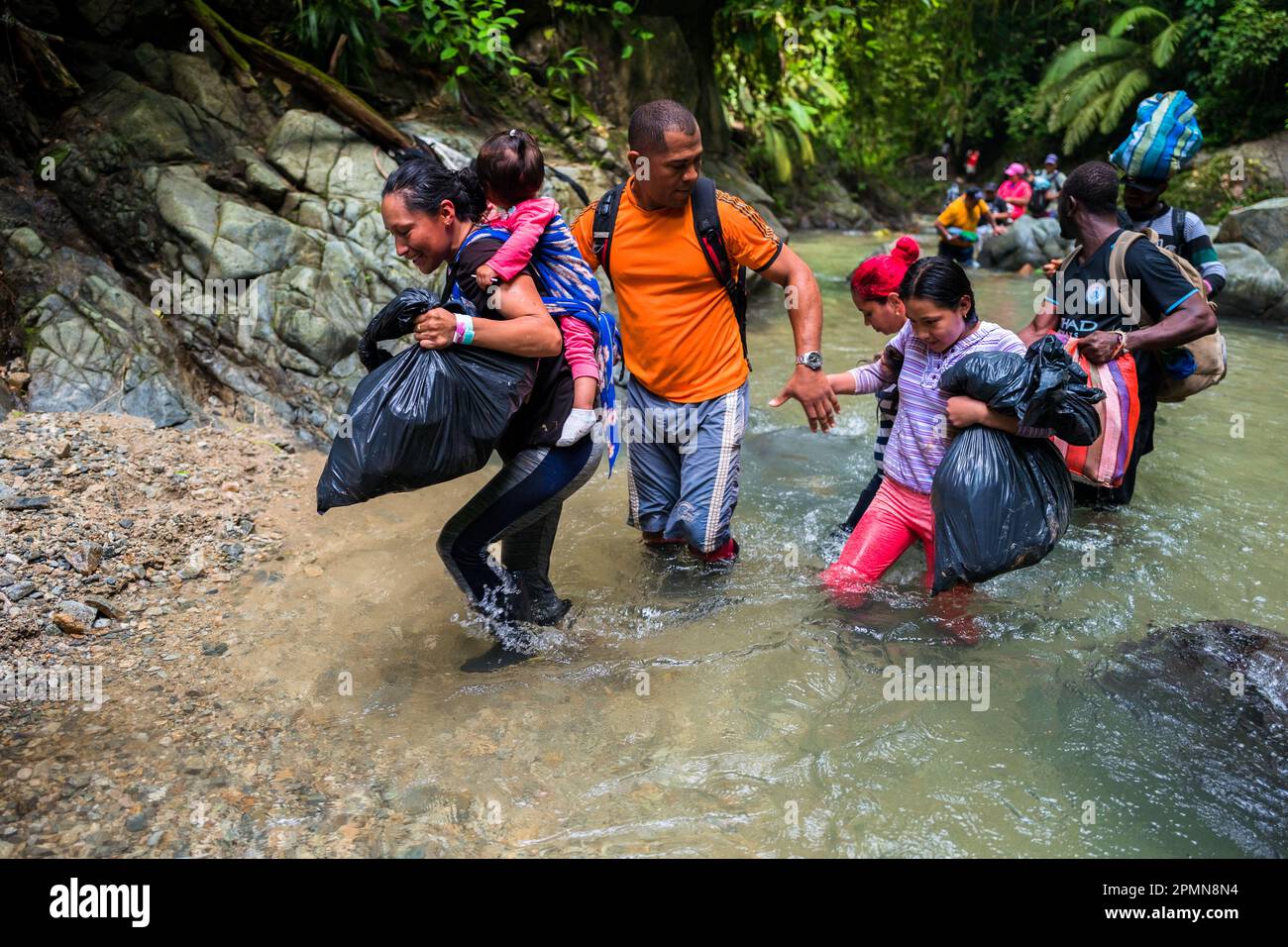 Una famiglia di migranti ecuadoriani svanisce attraverso il fiume nella giungla selvaggia e pericolosa del Darién Gap tra Colombia e Panamá. Foto Stock