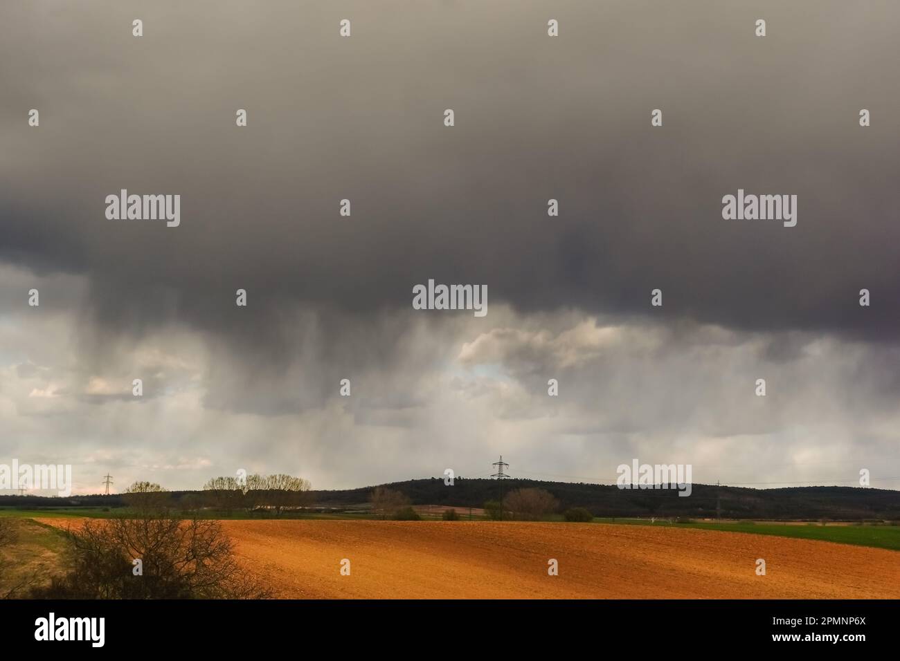 pioggia densa con nuvole scure e tempesta sui campi nel paesaggio naturale Foto Stock