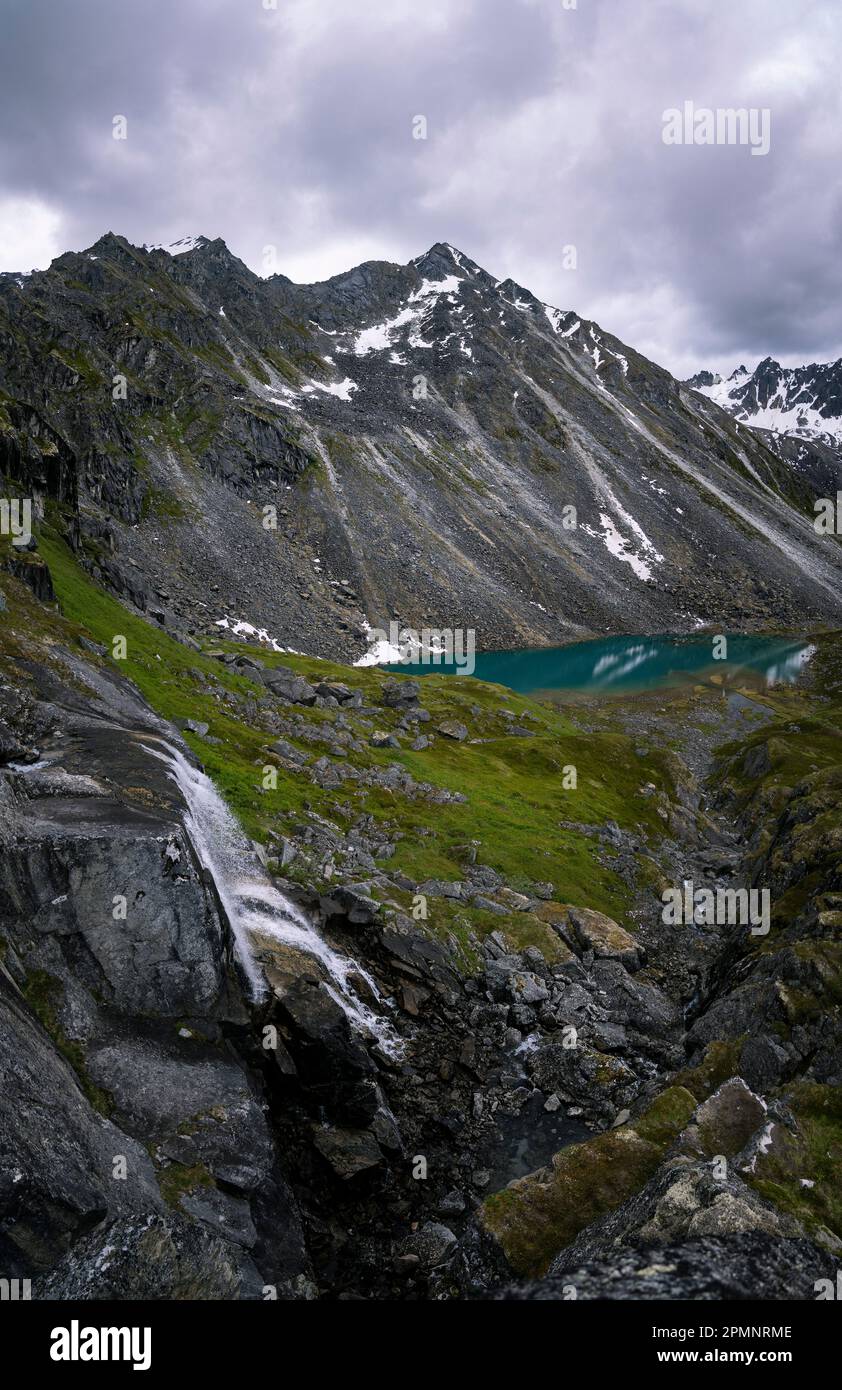Cascate e cime di granito all'Arch Angle Hatcher Pass sotto un cielo grigio e nuvoloso con le acque turchesi dei Reed Lakes vicino a Independe... Foto Stock