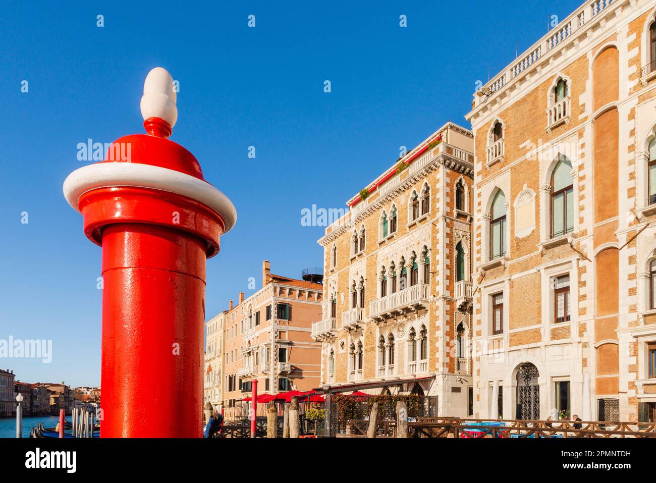 Primo piano di un palo del canale e di edifici storici lungo il Canal grande sullo sfondo; Veneto, Venezia, Italia Foto Stock