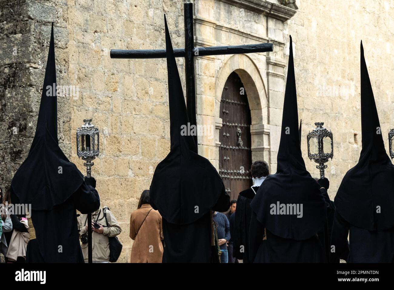 I penitenti che indossano cappe appuntite nere trasportano la croce di legno dalla St. Maria maggiore durante una settimana Santa o la processione di Semana Santa il Venerdì Santo, 6 aprile 2023 a Ronda, Spagna. Ronda, insediata per la prima volta nel 6th° secolo a.C., ha tenuto le processioni della settimana Santa per oltre 500 anni. Credit: Richard Ellis/Richard Ellis/Alamy Live News Foto Stock