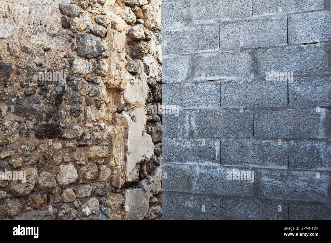 Muro di blocco di cenere opposto ad un muro di pietra Foto Stock
