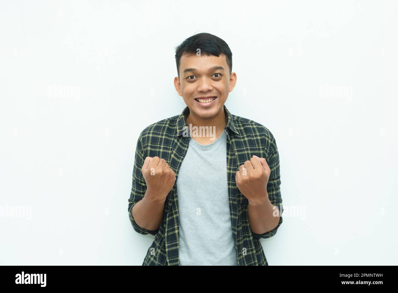 Giovane asiatico sorridente e mostrando sì o espressione di gesto di successo Foto Stock