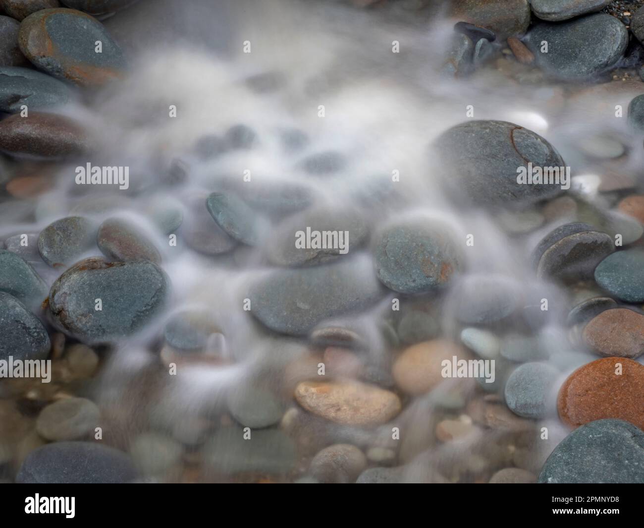 L'acqua di mare sfocata si bagna sui ciottoli della spiaggia; Greymouth, South Island, nuova Zelanda Foto Stock