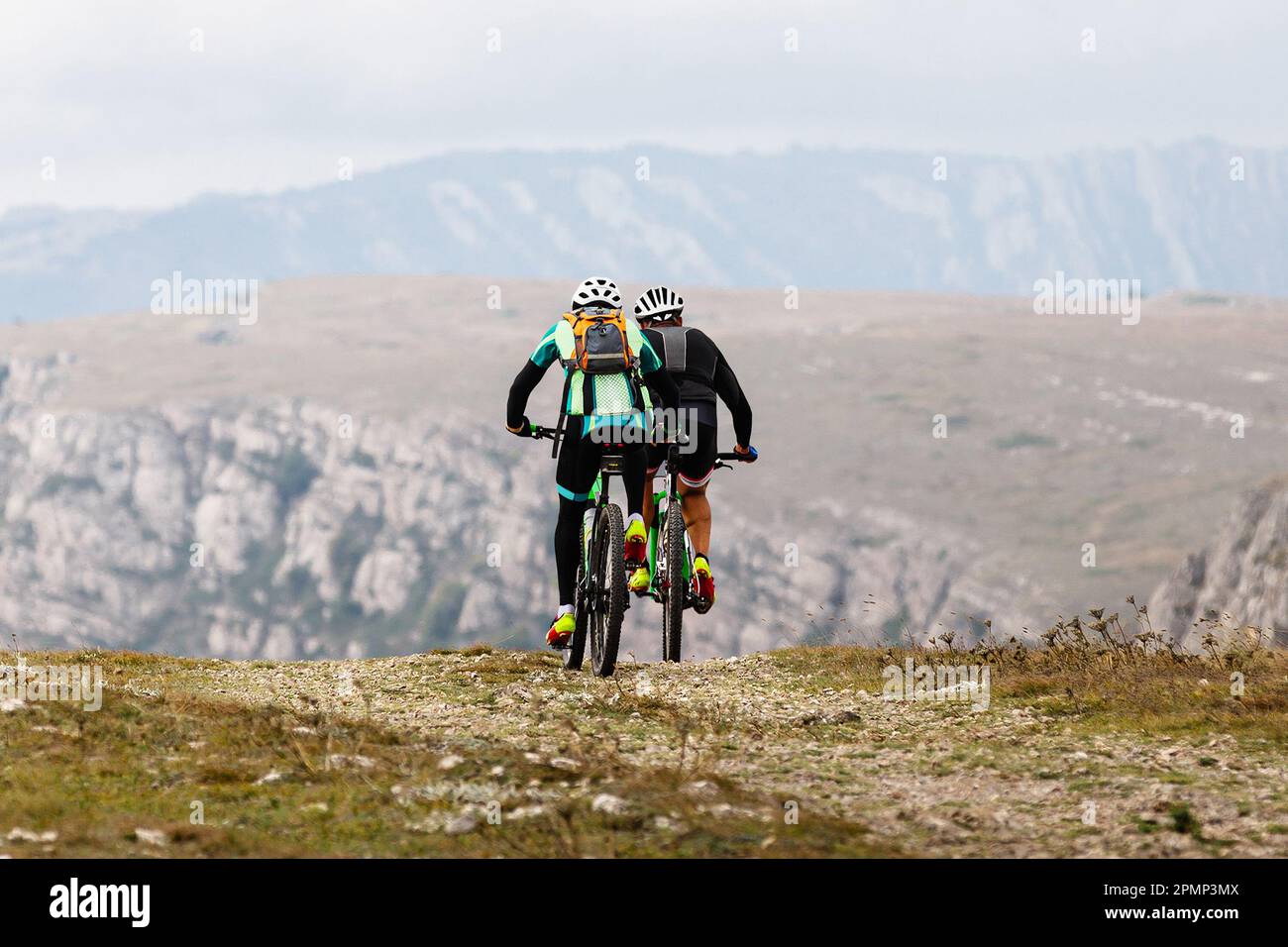 due ciclista maschi in mountain bike nella regione montuosa in viaggio in bicicletta. zaino sul retro del mountain bike Foto Stock