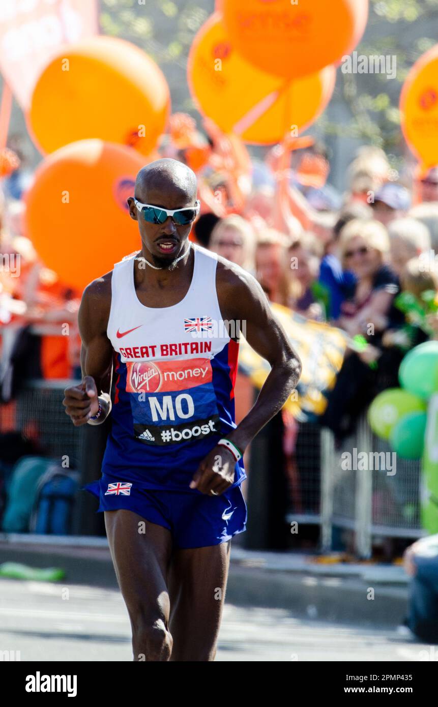 MO Farah gareggia nella Maratona di Londra 2014, passando attraverso Tower Hill vicino alla Torre di Londra, Regno Unito. Giubbotto Gran Bretagna, atleta britannico d'élite Foto Stock