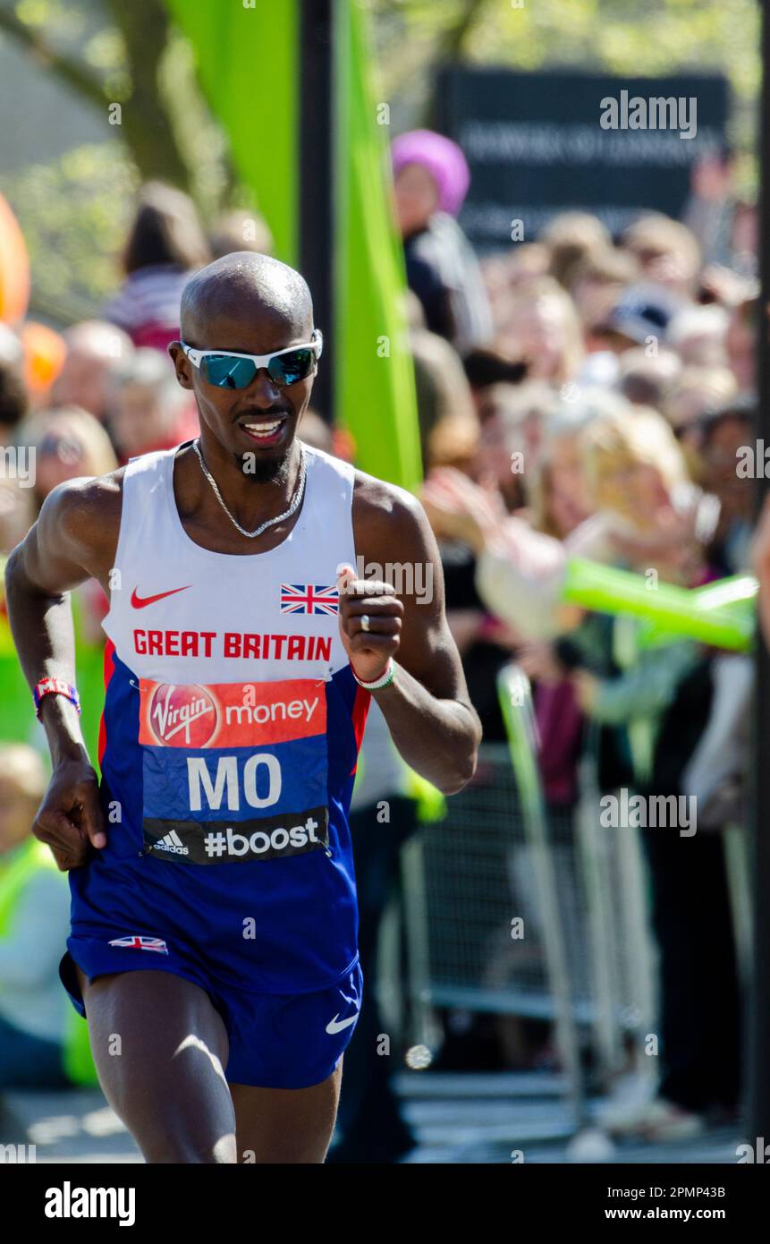 MO Farah gareggia nella Maratona di Londra 2014, passando attraverso Tower Hill vicino alla Torre di Londra, Regno Unito. Giubbotto Gran Bretagna, atleta britannico d'élite Foto Stock