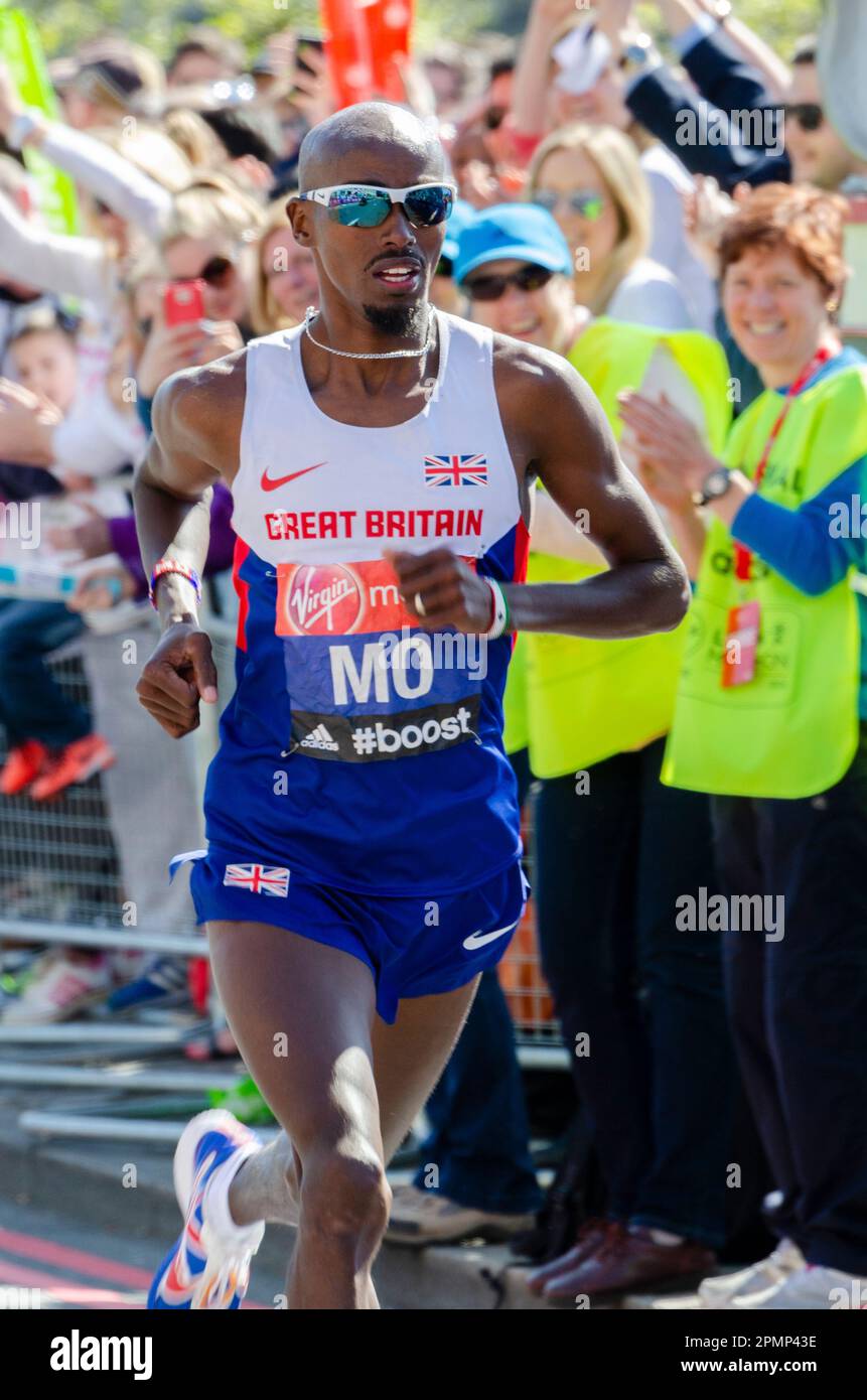 MO Farah gareggia nella Maratona di Londra 2014, passando attraverso Tower Hill vicino alla Torre di Londra, Regno Unito. Giubbotto Gran Bretagna, atleta britannico d'élite Foto Stock