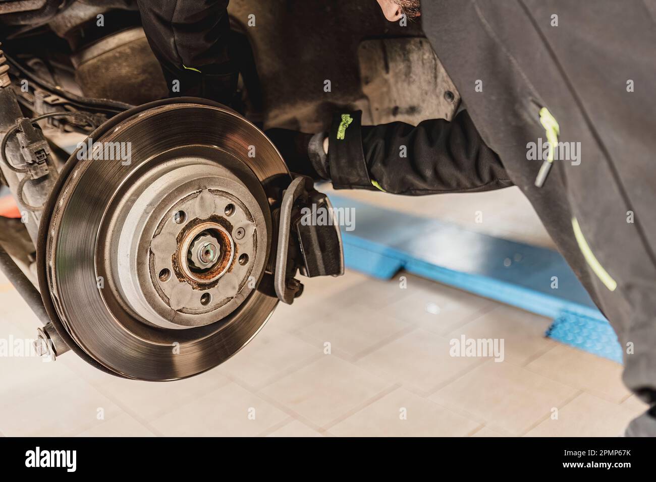 Un meccanico esperto sostituisce le pastiglie dei freni di una vettura con precisione e cura. Foto Stock
