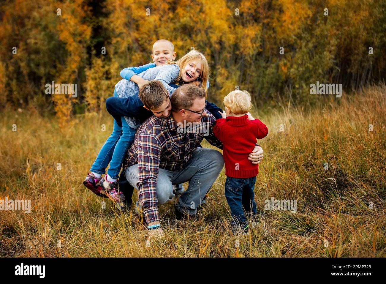 Padre che abita con i suoi quattro figli all'aperto in un parco cittadino in autunno; Edmonton, Alberta, Canada Foto Stock