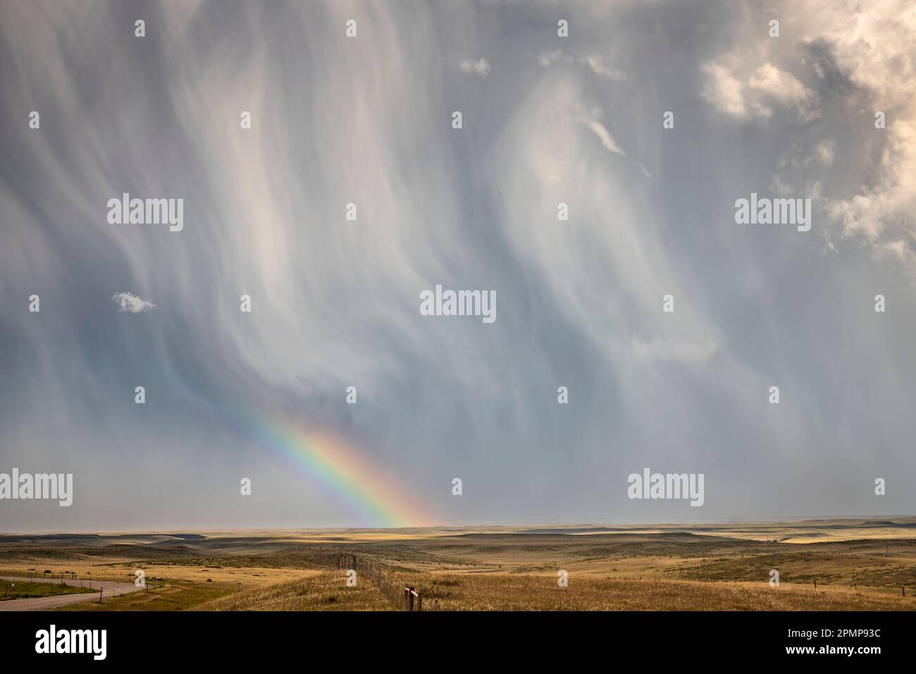 Grande nuvola di tempesta testurizzata che scarica pioggia e grandine ma condivide un meraviglioso arcobaleno vicino a Chugwater, Wyoming, Stati Uniti d'America Foto Stock