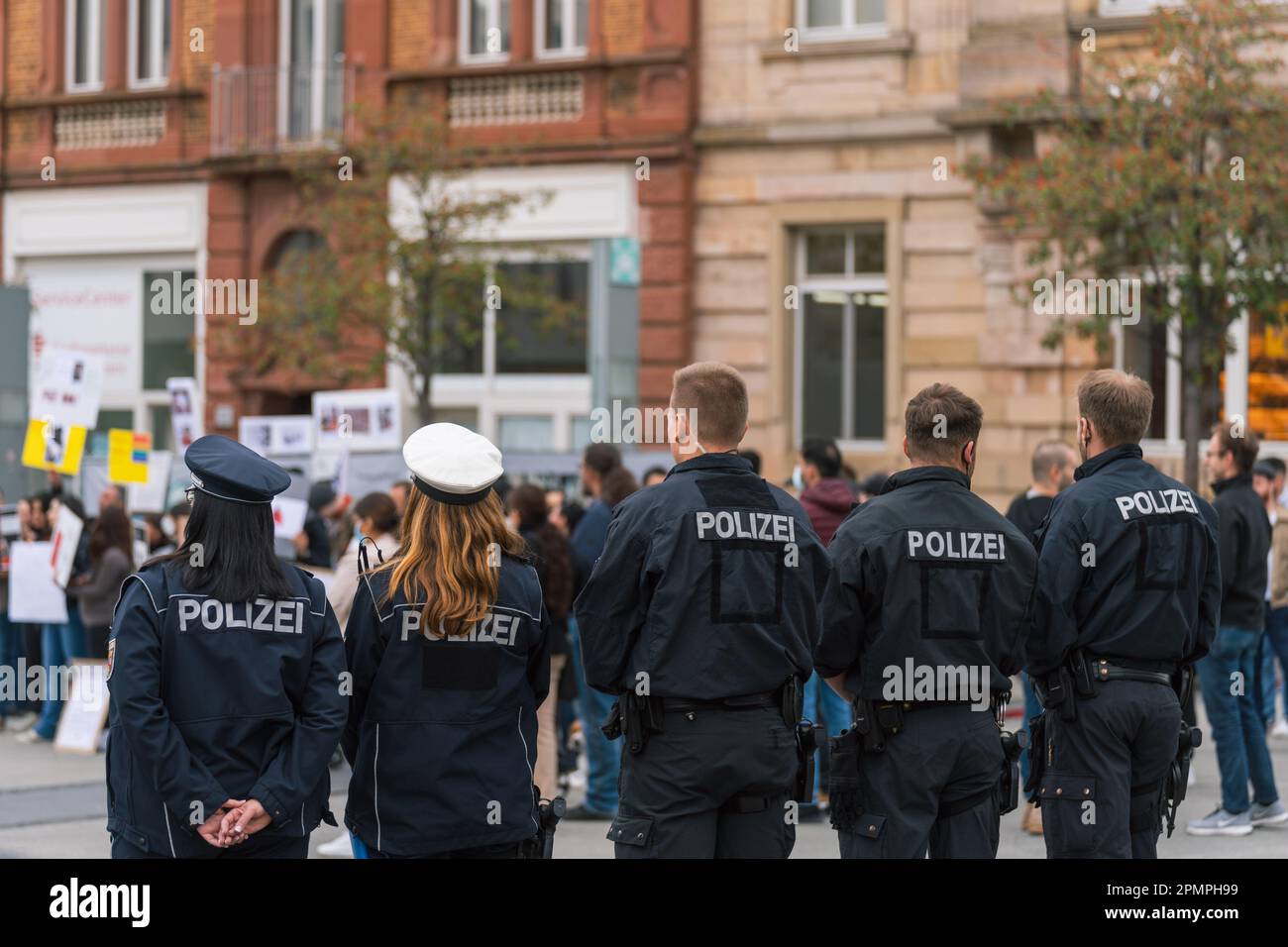 Poliziotti e donne tedeschi in fila, garantendo la sicurezza durante una protesta contro l'oppressione delle donne in Iran, Kaiserslautern, Germania Foto Stock