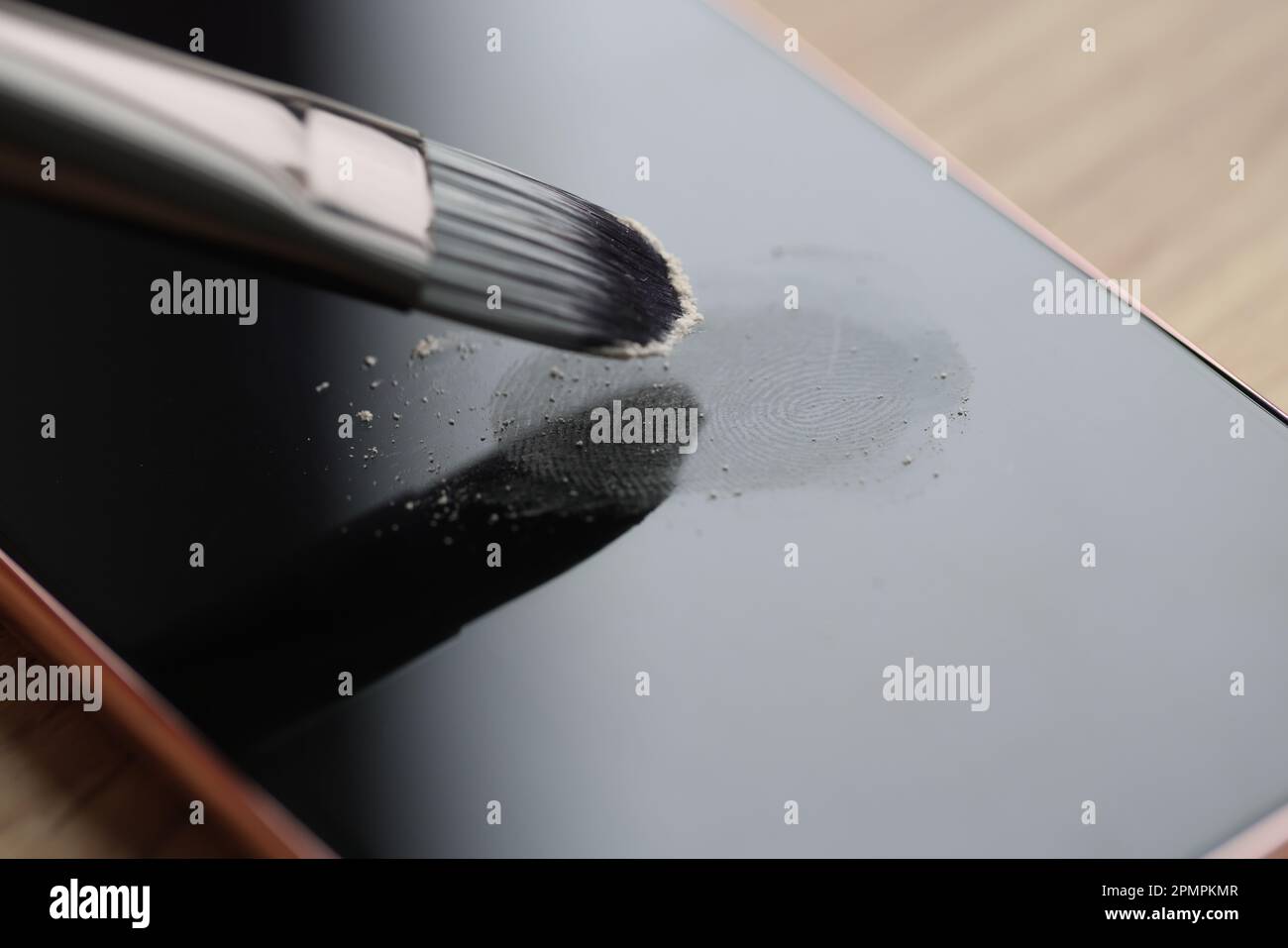 Il pennello piccolo elabora le impronte digitali lasciate sullo schermo del telefono Foto Stock