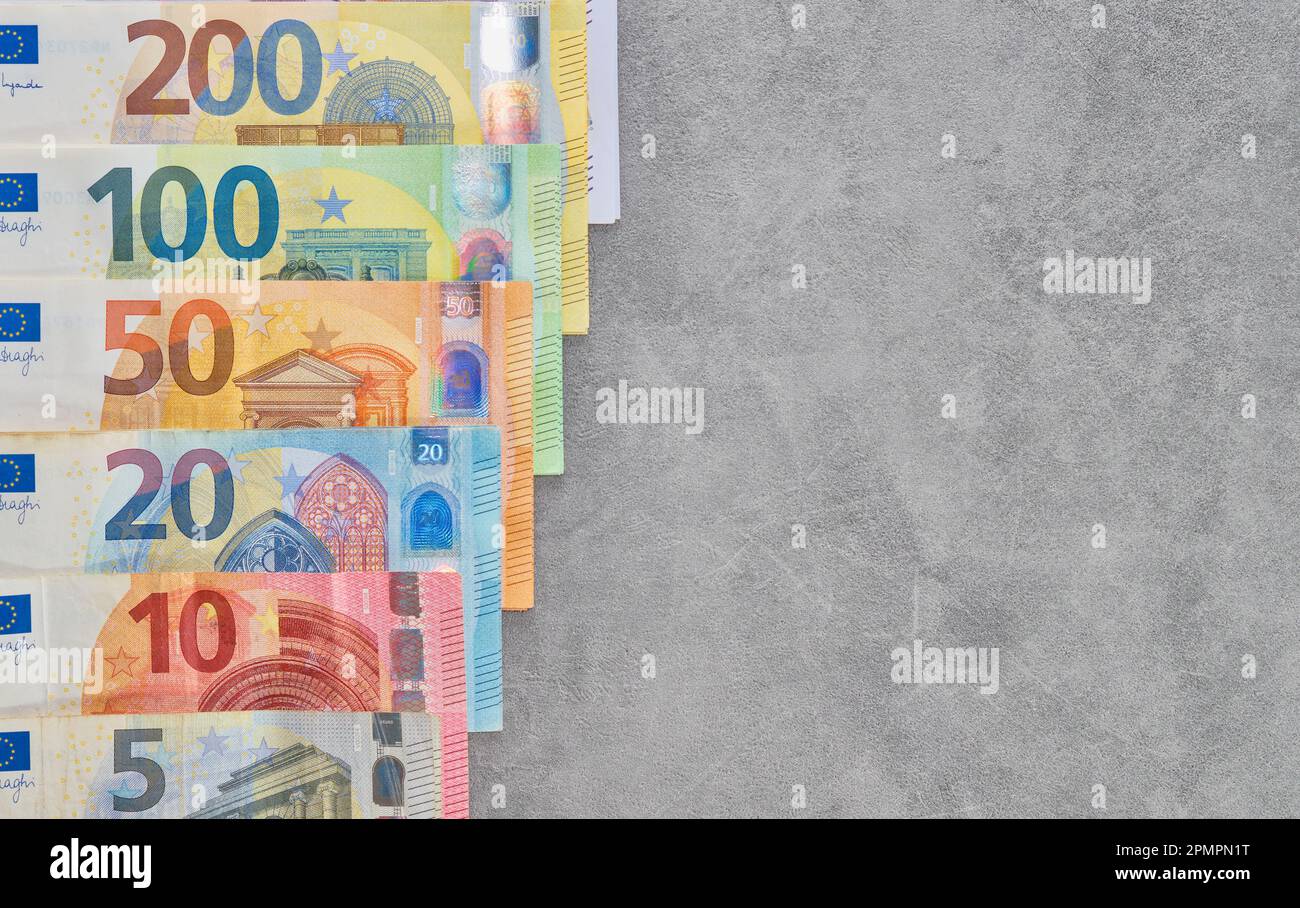Le banconote in euro sono disposte su sfondo grigio, vista dall'alto delle banconote in euro di diversi tagli in contanti, sistema di pagamento del conto dell'Unione europea Foto Stock
