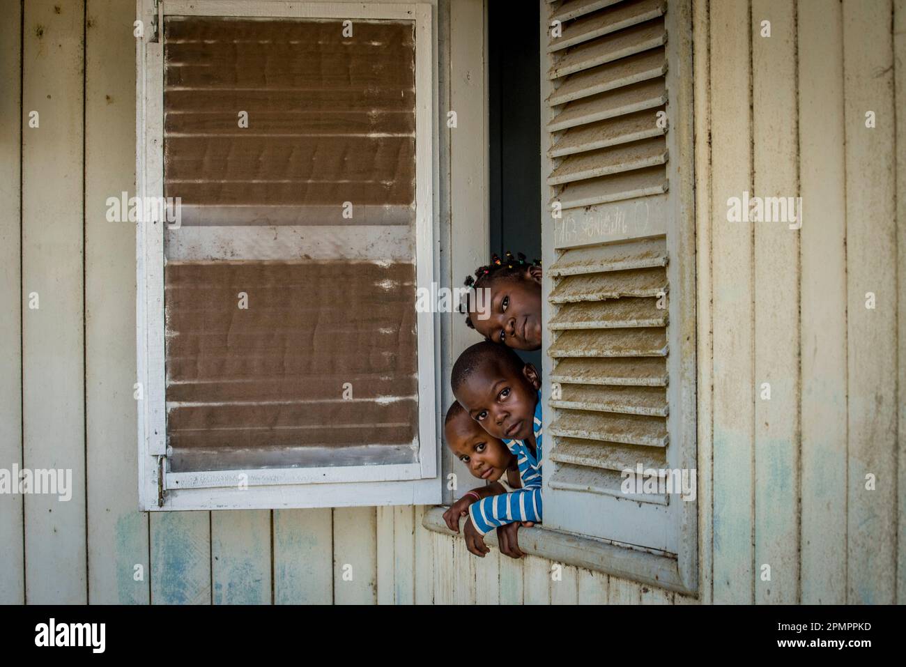 Tre fratelli si trovano a casa loro nella “città delle aziende” di Socapalm, nel distretto di Kribi in Camerun. La zona è sede di grandi piantagioni di olio di palma, un Foto Stock