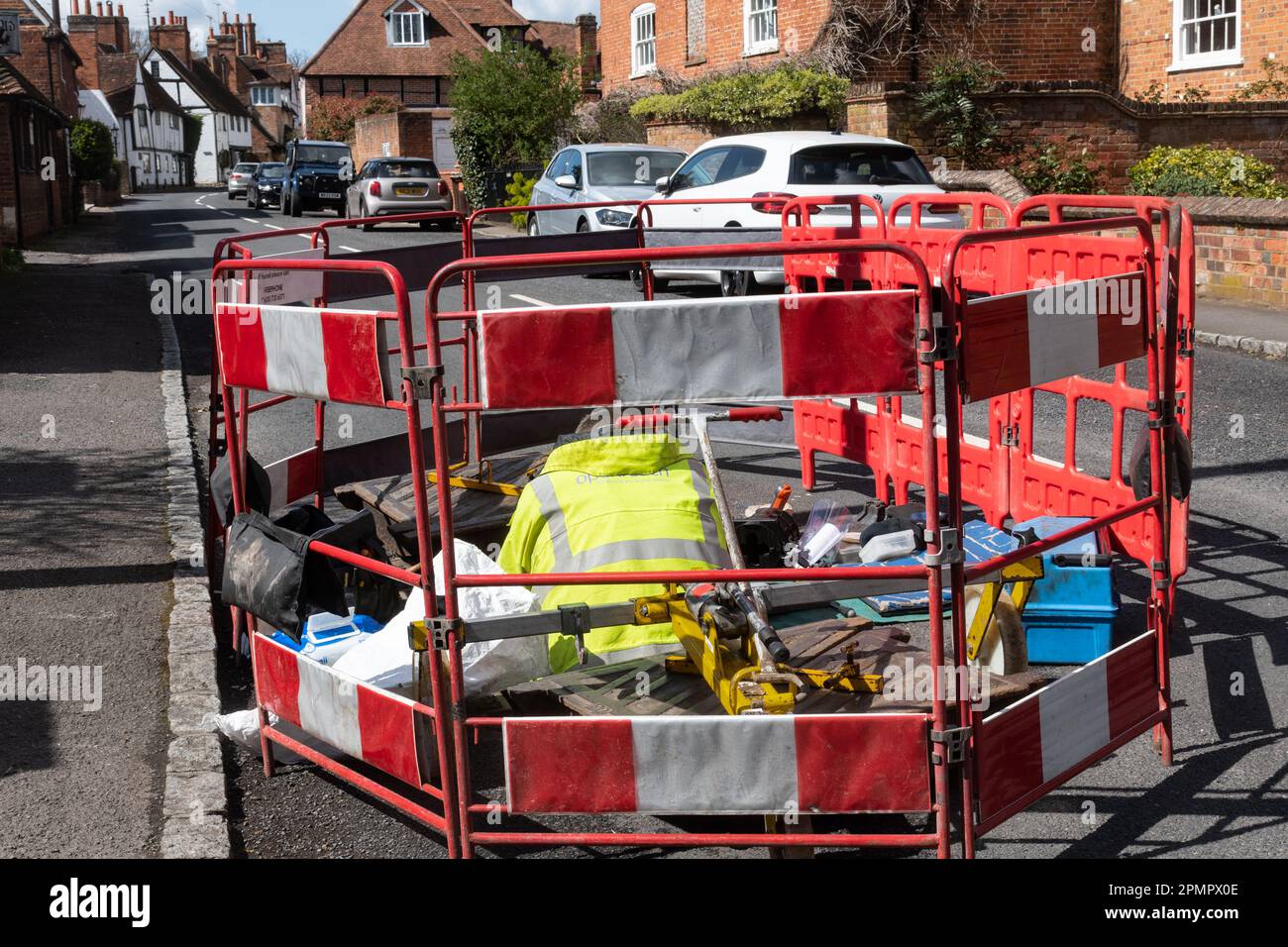 Ingegnere OpenReach che lavora in un buco della strada in un villaggio inglese, Berkshire, Inghilterra, Regno Unito Foto Stock