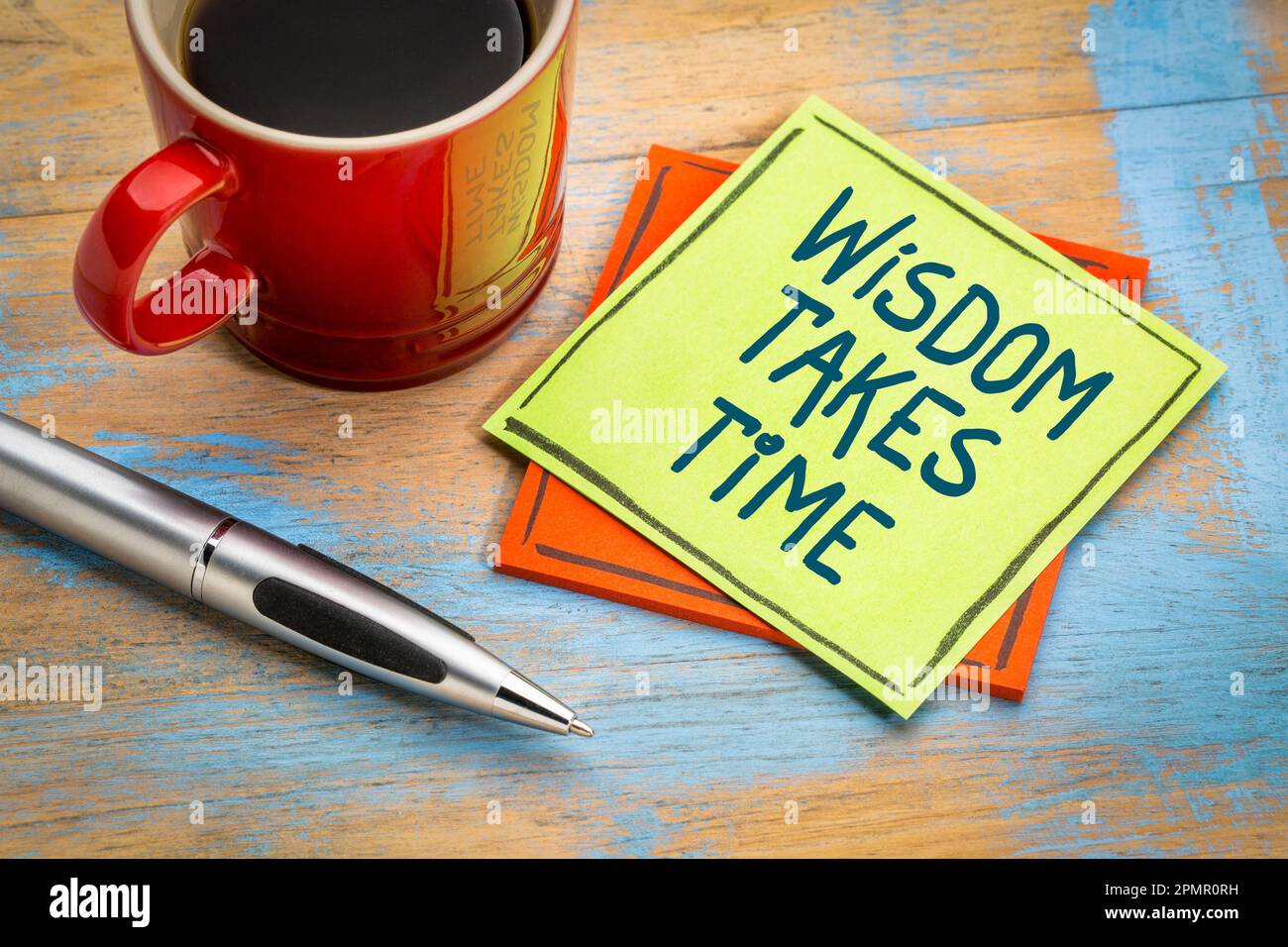 La saggezza richiede tempo. Nota di promemoria con una tazza di caffè. Rimanere pazienti e impegnati nella ricerca della conoscenza e della saggezza. Foto Stock