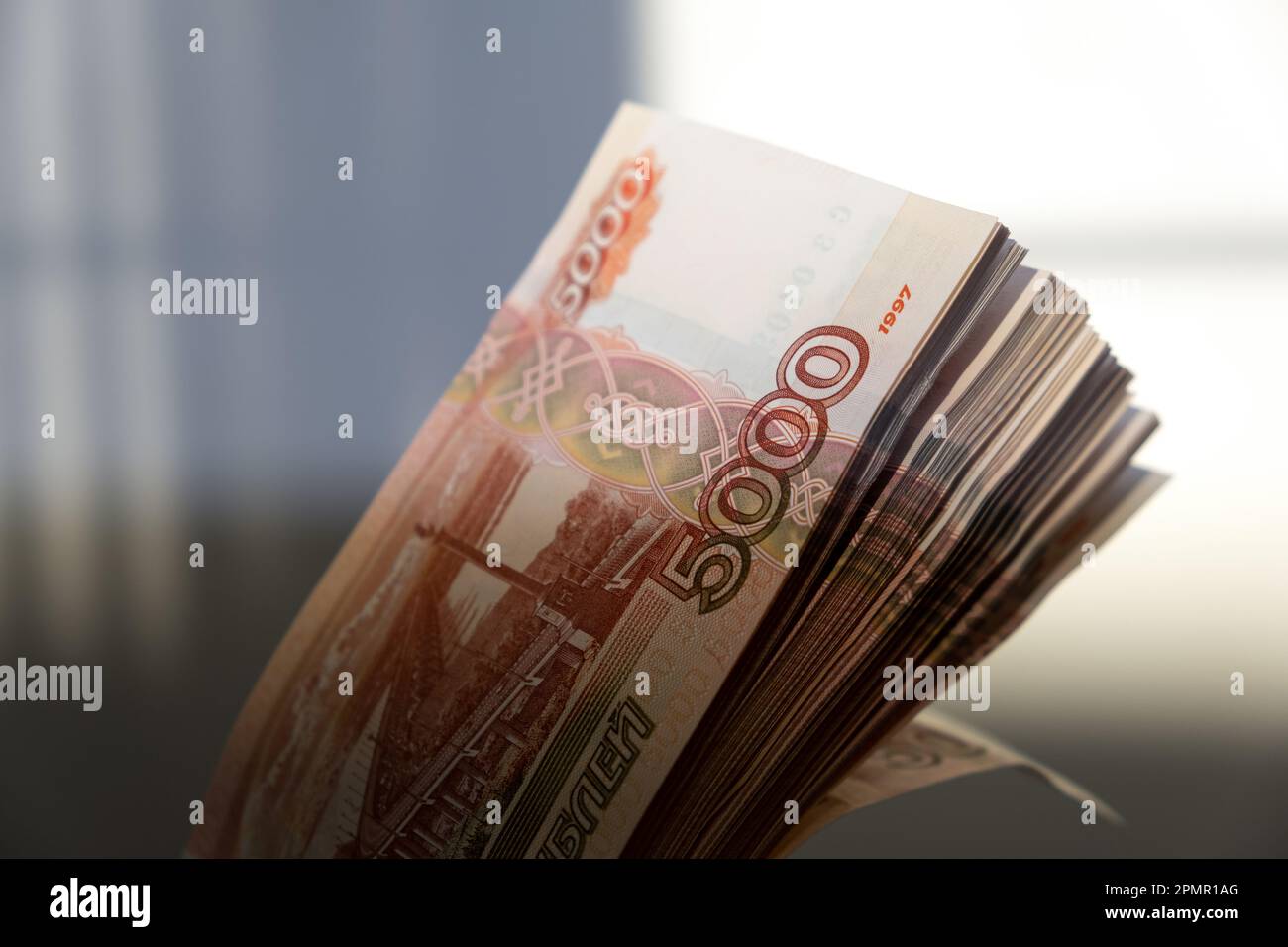 I soldi russi rubano. Cinque millesimi di banconote in contanti. Una pila di soldi in una mano femminile con una manicure francese Foto Stock