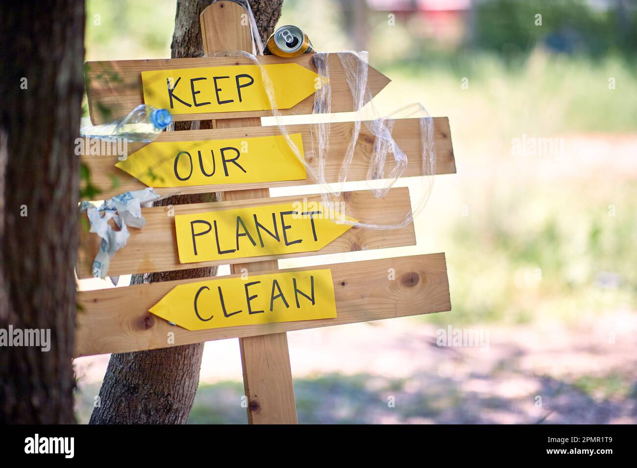 Vista ravvicinata sul cartello con gli slogan ecologici nella foresta in una bella giornata di sole. Ecologia, persone, cura Foto Stock