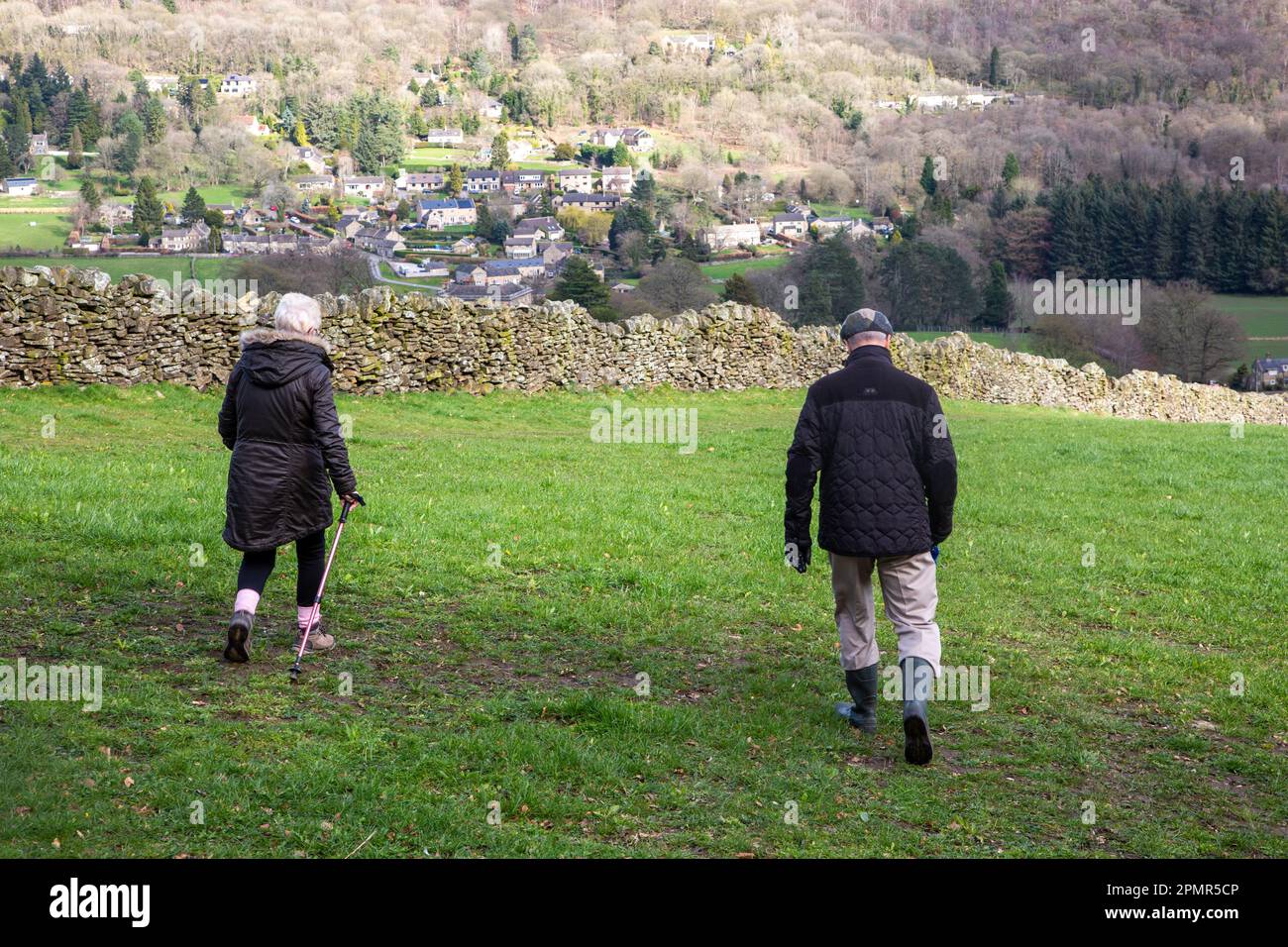 Anziani pensionati che camminano nelle colline del Derbyshire Peak District sopra il villaggio di Froggott Foto Stock
