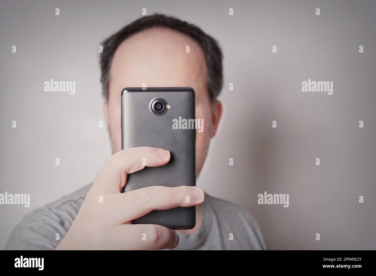 uomo che guarda lo smartphone o che fotografa selfie con un camear mobile Foto Stock