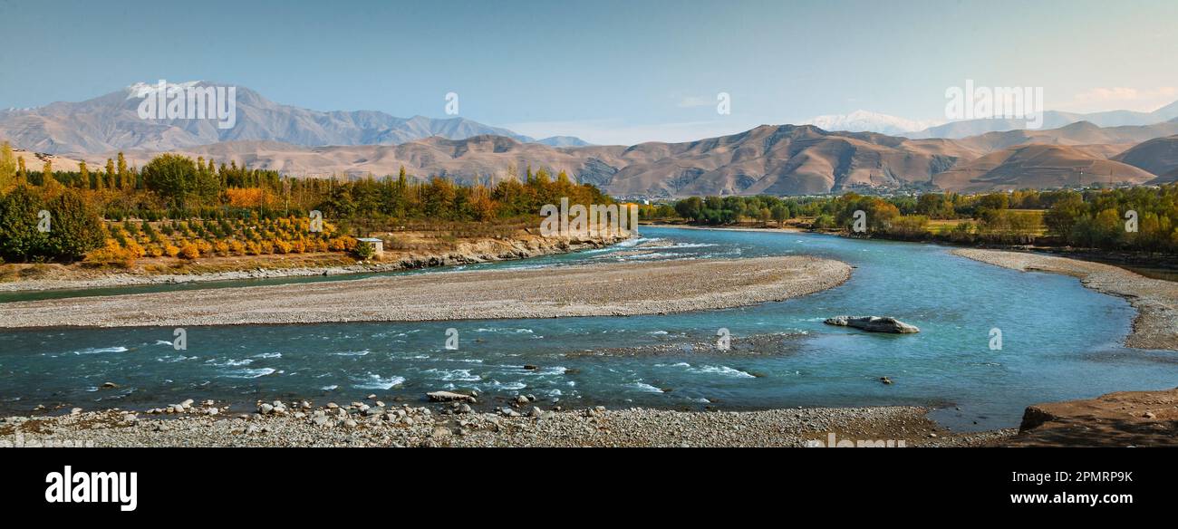 Una vista di un fiume Kokcha che passa attraverso alberi e montagne; Fayzabad, Badakhshan, Afghanistan Foto Stock