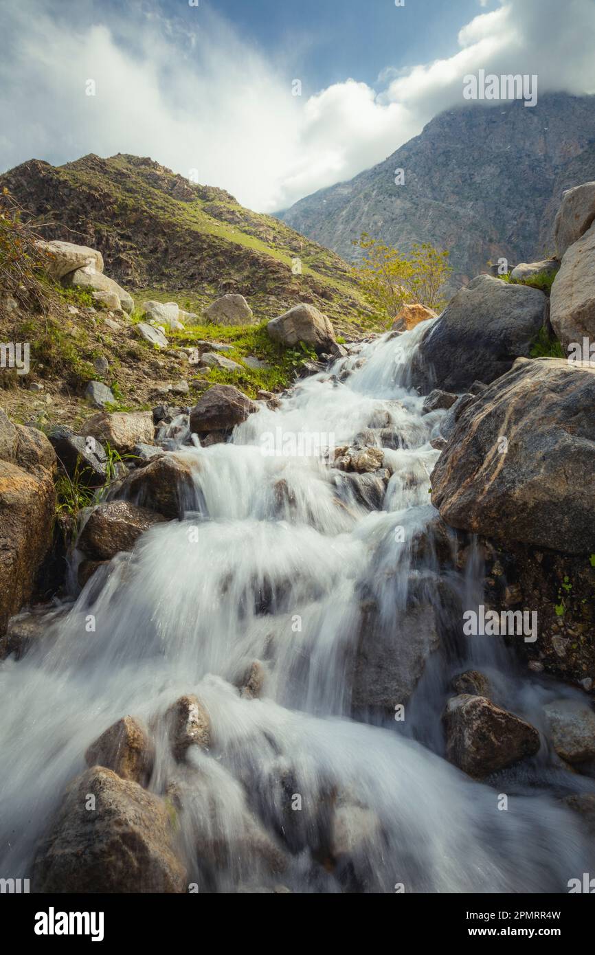 Una bella foto di una cascata con le montagne sullo sfondo; Badakhshan, Afghanistan Foto Stock