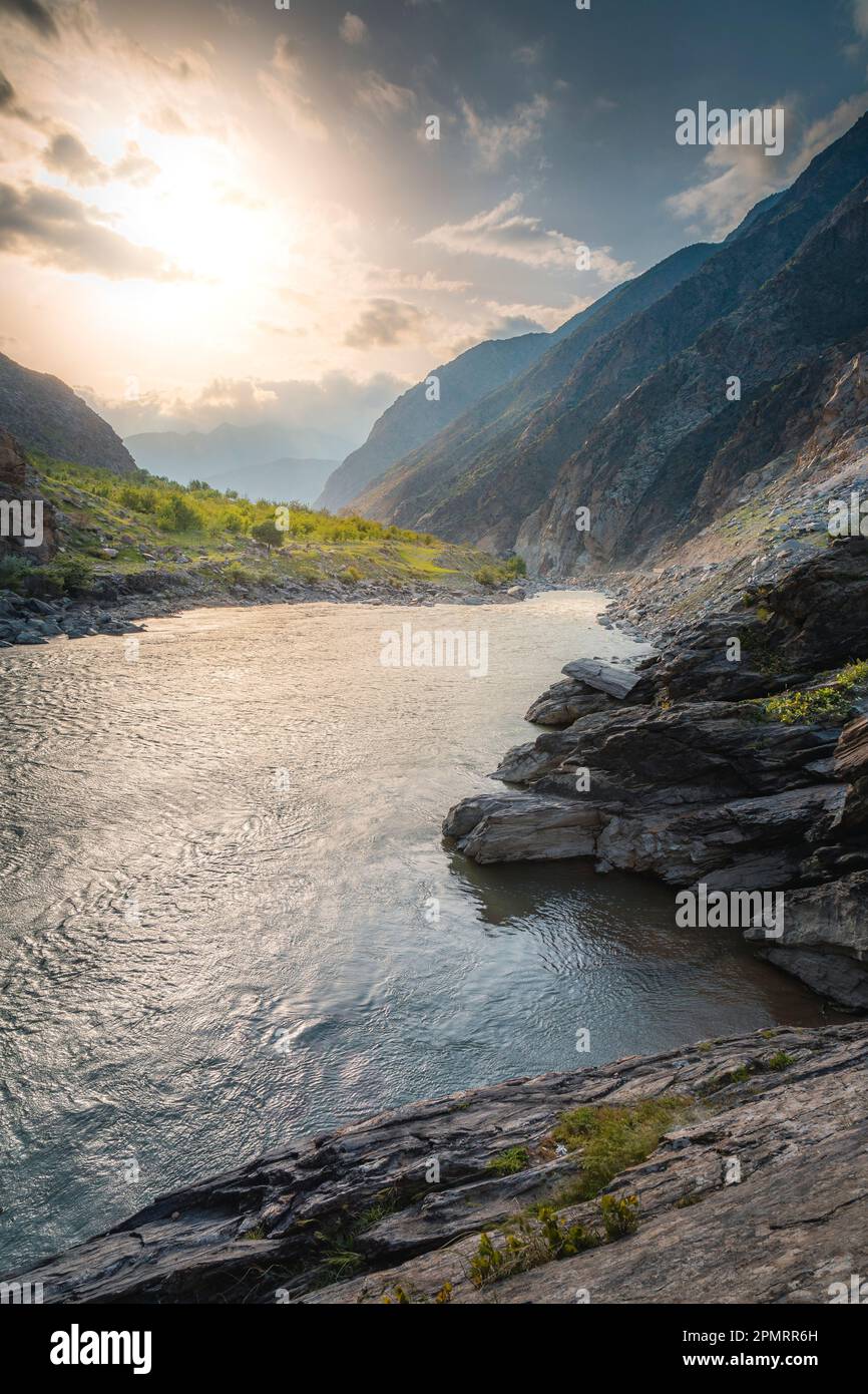 Una foto al tramonto del fiume Kokcha e degli alberi con le montagne sullo sfondo; Badakhshan, Afghanistan Foto Stock