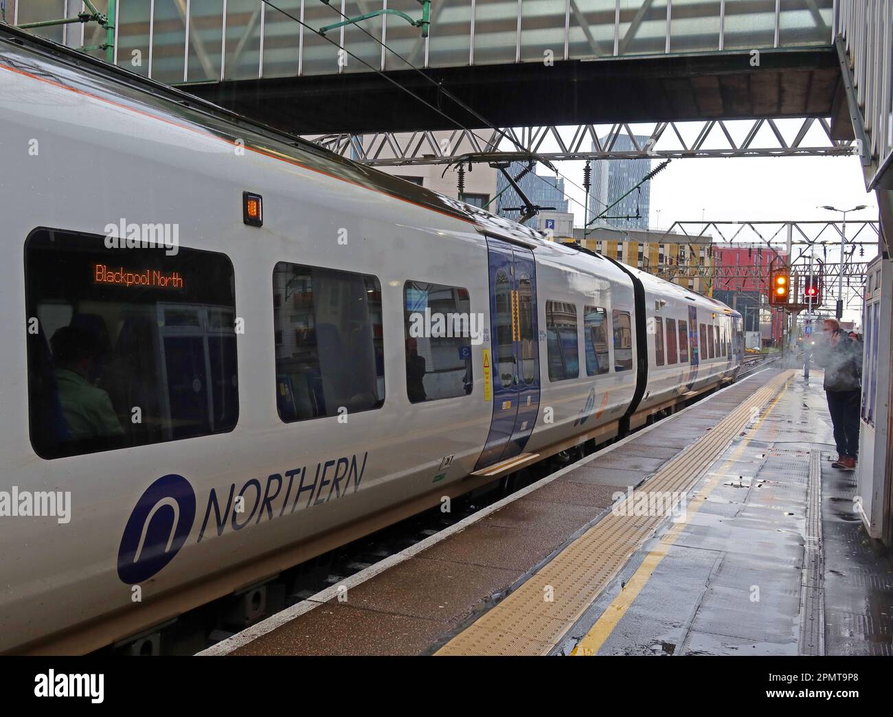 Servizio ferroviario Northern, EMU - unità elettrica multipla, su una piattaforma piovosa, alla stazione ferroviaria Manchester Oxford Road, Inghilterra, Regno Unito, M1 6FU Foto Stock