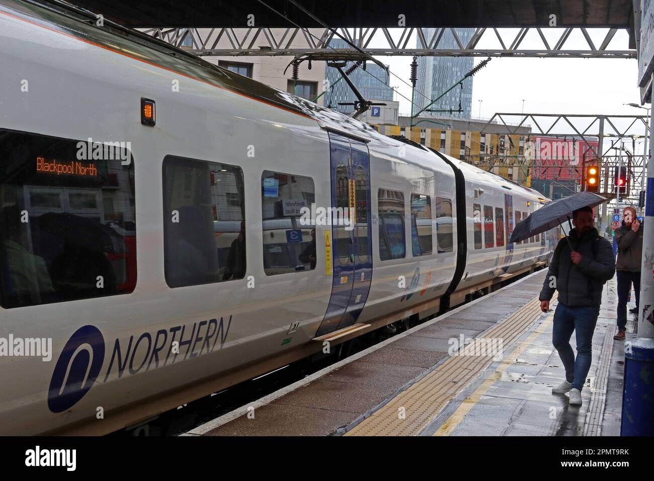 Servizio ferroviario Northern, EMU - unità elettrica multipla, su una piattaforma piovosa, alla stazione ferroviaria Manchester Oxford Road, Inghilterra, Regno Unito, M1 6FU Foto Stock