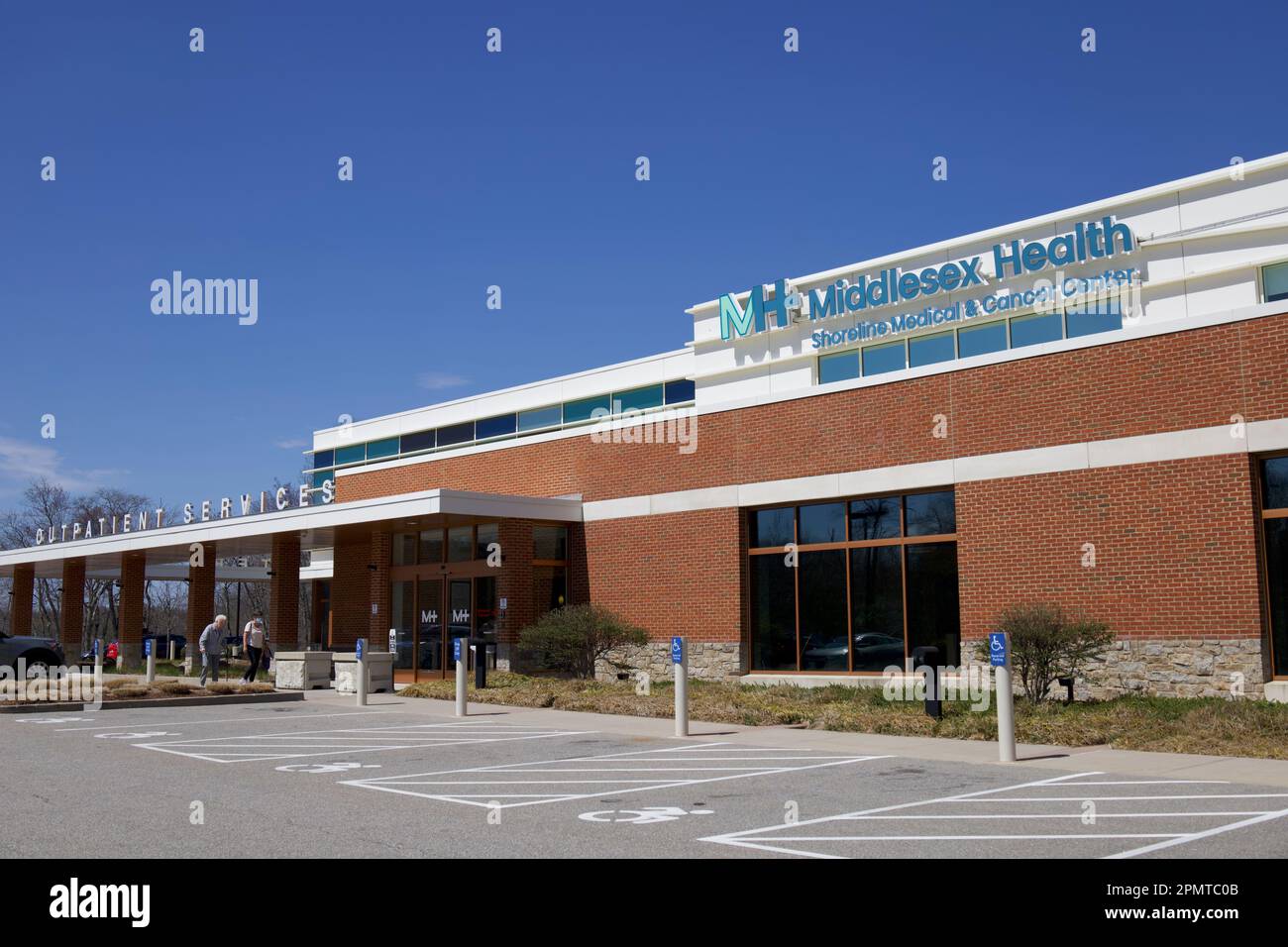 Ingresso per i servizi ambulatoriali al Middlesex Health Shoreline Medical and Cancer Center. Esterno con parcheggio per disabili di fronte. Persone che camminano dentro. Foto Stock