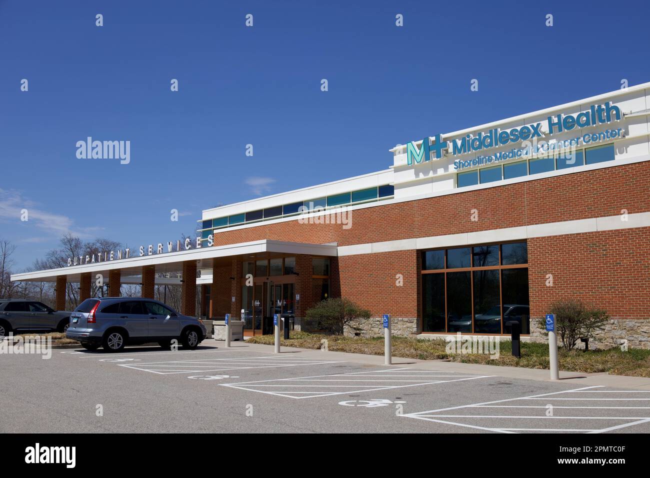 Ingresso per i servizi ambulatoriali al Middlesex Health Shoreline Medical and Cancer Center. Esterno con parcheggio per disabili di fronte e auto. Foto Stock