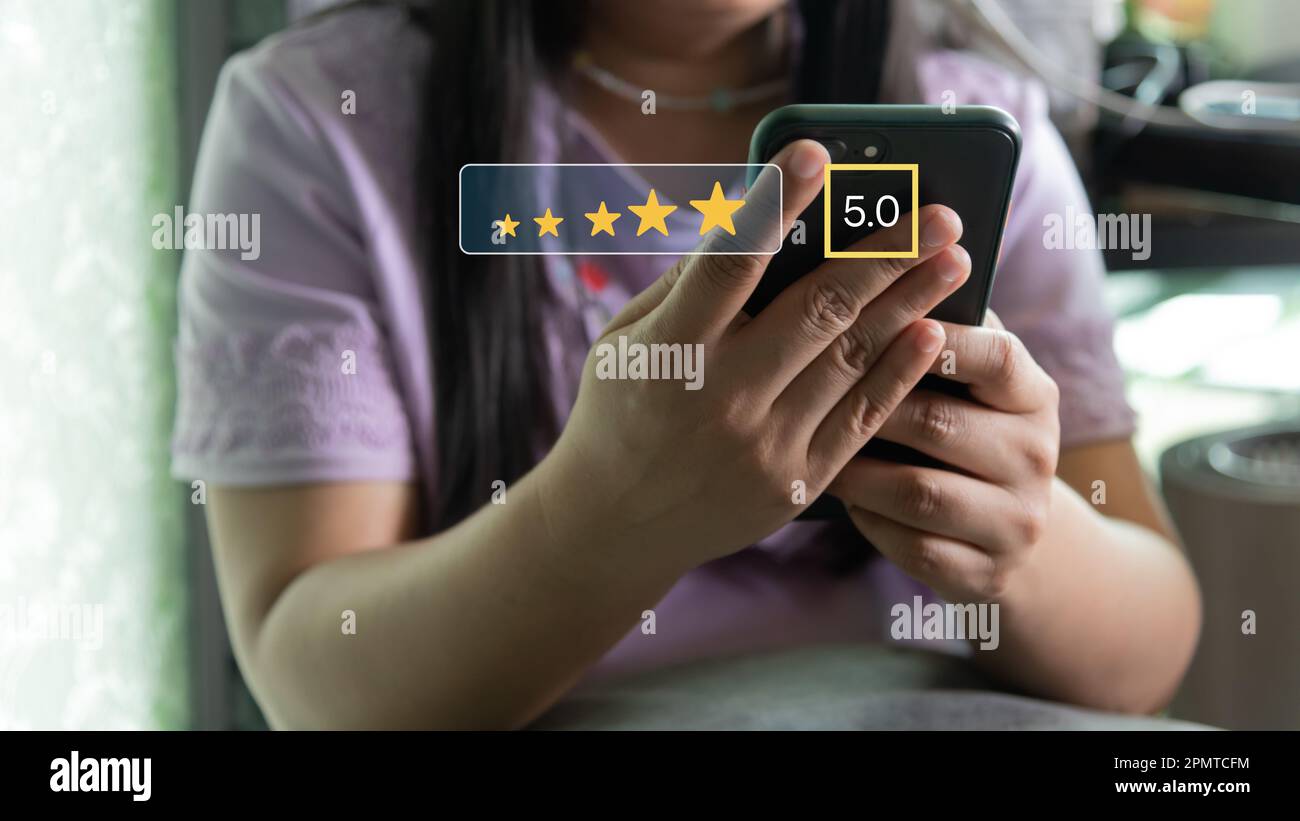 Concetto di valutazione della soddisfazione del servizio clienti. Uomo che utilizza lo smartphone e che tocca lo schermo con cinque stelle dorate eccellente feedback icona, tasso Foto Stock