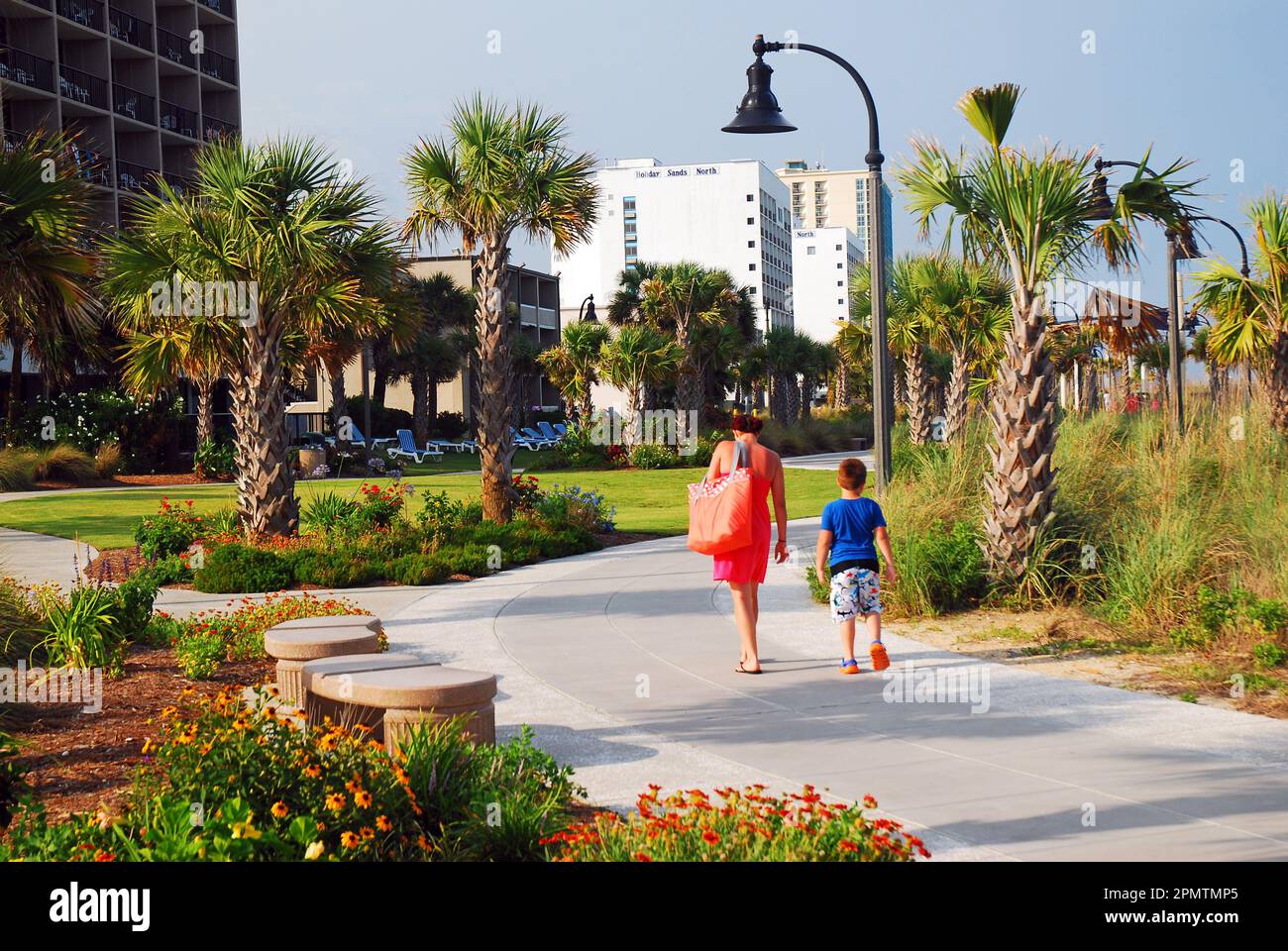 Una passeggiata tra madre e figlio sul lungomare durante una giornata estiva di vacanza in famiglia vicino alla riva di Myrtle Beach, South Carolina Foto Stock