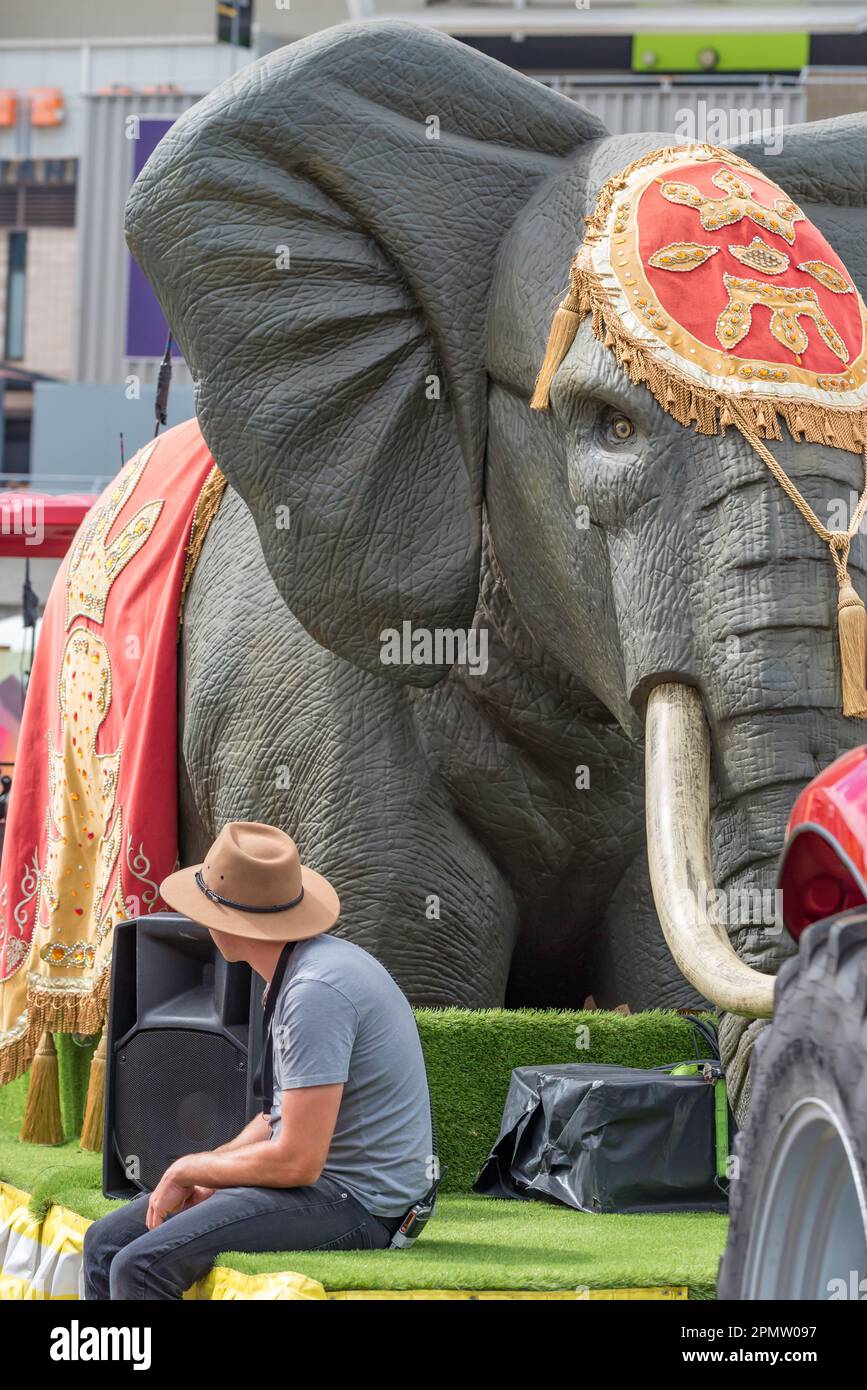 Un giovane che indossa un tradizionale cappello da sposa in stile Akubra si siede e attende accanto a un gigantesco elefante falso prima che una processione inizi al Royal Easter Show 2023 a Sydney, Australia. Foto Stock