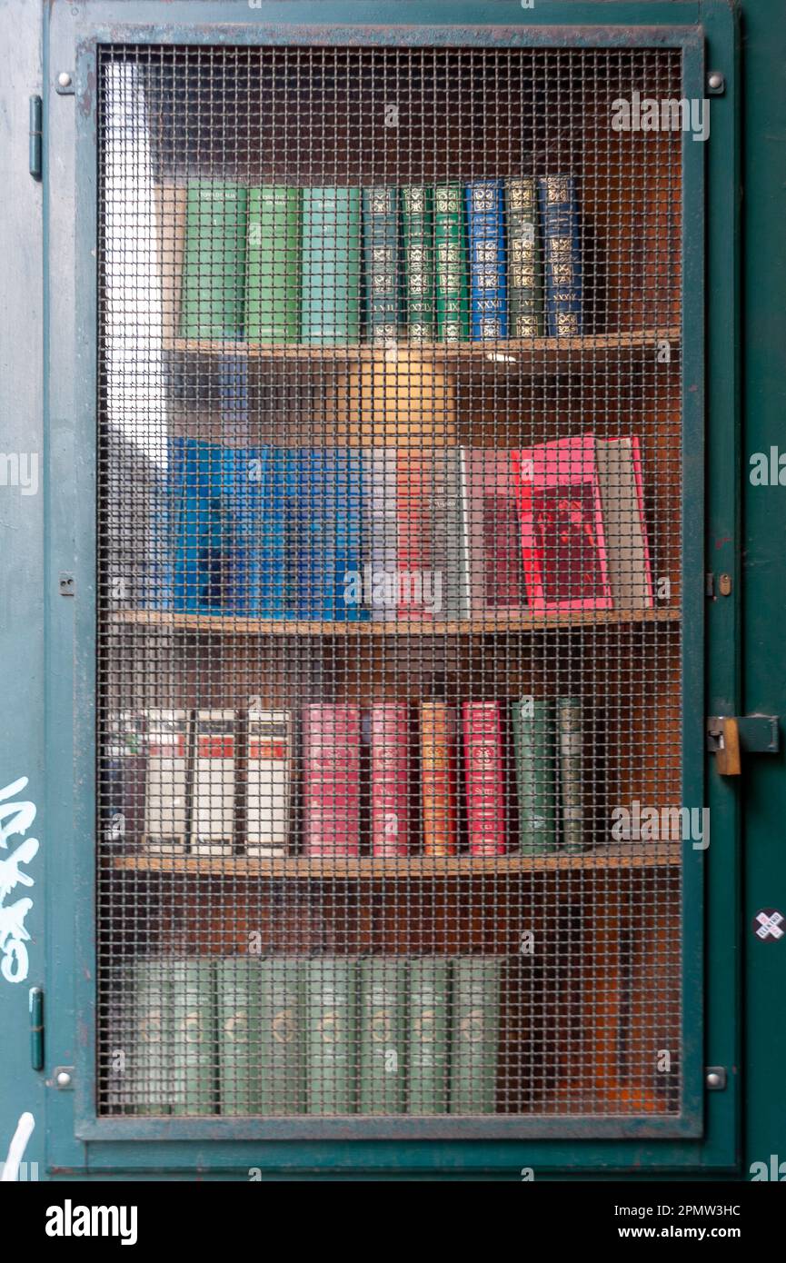Vetrina di libri usati protetti da una grata. Foto Stock