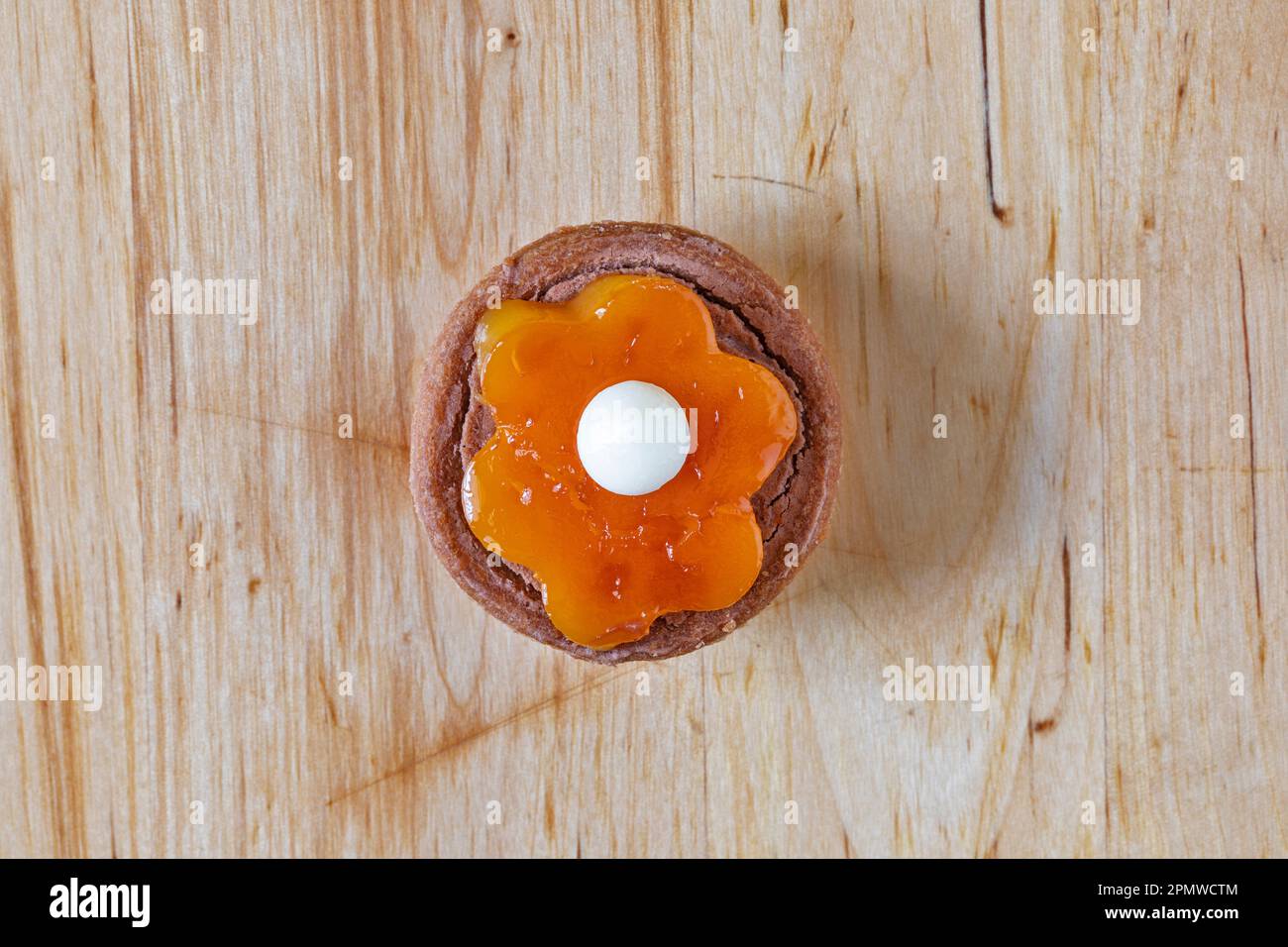Piccolo tartelletto rotondo con decorazione floreale. Su un vecchio tavolo di legno. Foto Stock