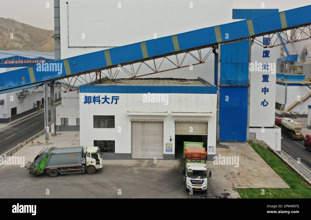 Tangshan. 13th Apr, 2023. Questa foto aerea scattata il 13 aprile 2023 mostra un camion dei rifiuti che scarica rifiuti presso la fabbrica di Tangshan Jidong Qixin Cement Co., Ltd. A Tangshan, nella provincia di Hebei della Cina settentrionale. La storia di Tangshan Jidong Qixin Cement Co., Ltd., precedentemente nota come Tangshan Qixin Cement Plant, risale al 1889. Negli ultimi anni, l'azienda è passata a una modalità di sviluppo ecologico di alta qualità, ottenendo vantaggi sia economici che ecologici. Credit: MU Yu/Xinhua/Alamy Live News Foto Stock