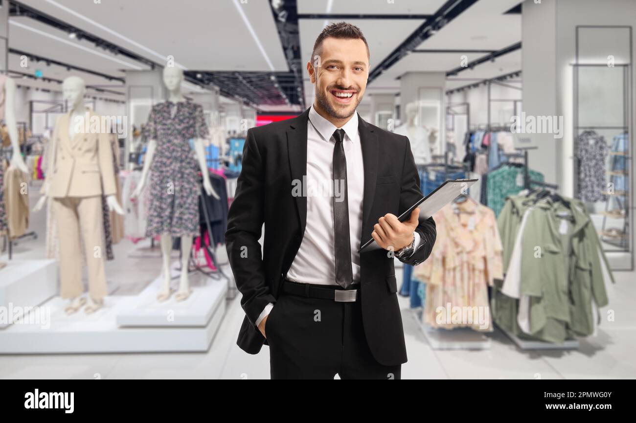 Retail Manager che tiene una clipboard con un documento in un negozio di abbigliamento Foto Stock