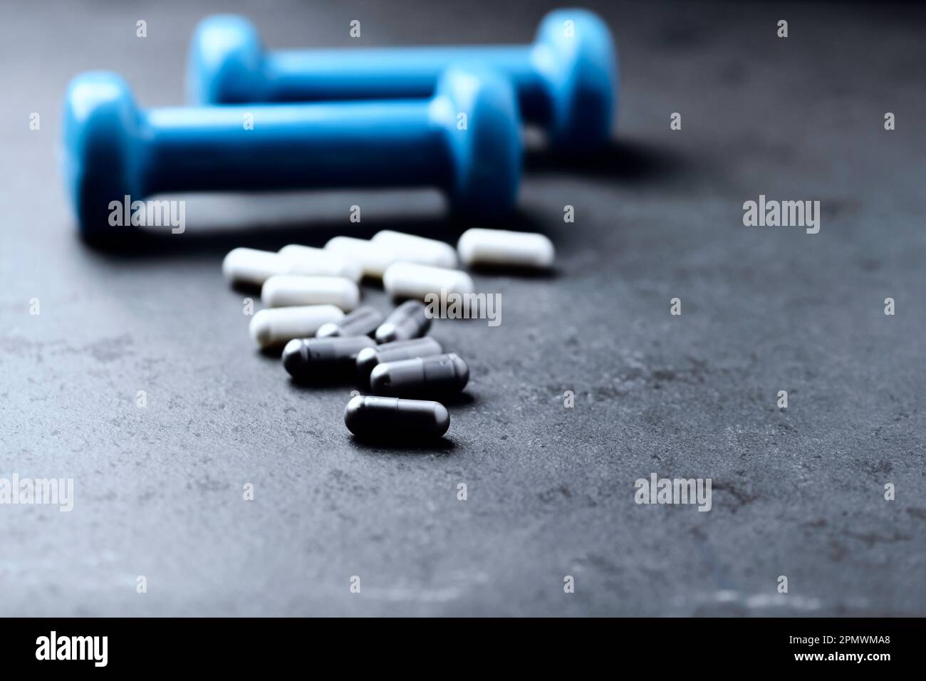 Capsule di BCAA e creatie. Bodybuilding integratori alimentari su sfondo di pietra scura. Messa a fuoco morbida. Primo piano. Spazio di copia. Foto Stock