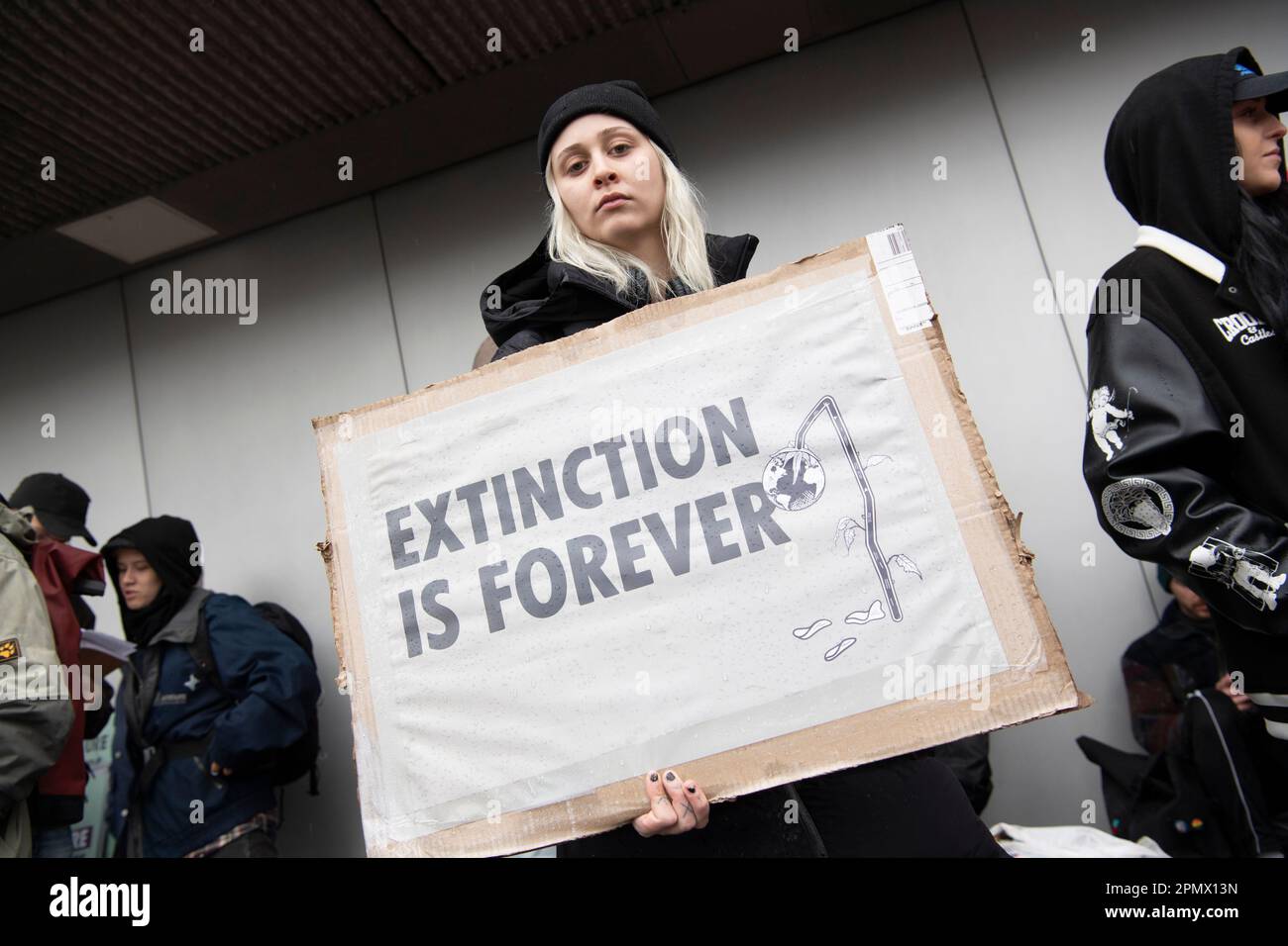 Berlino, Germania. 15th Apr, 2023. Un partecipante alla manifestazione del gruppo di protezione del clima Extinction Rebellion attende l'inizio della processione presso la sede della Bayer AG. Credit: Paul Zinken/dpa/Alamy Live News Foto Stock