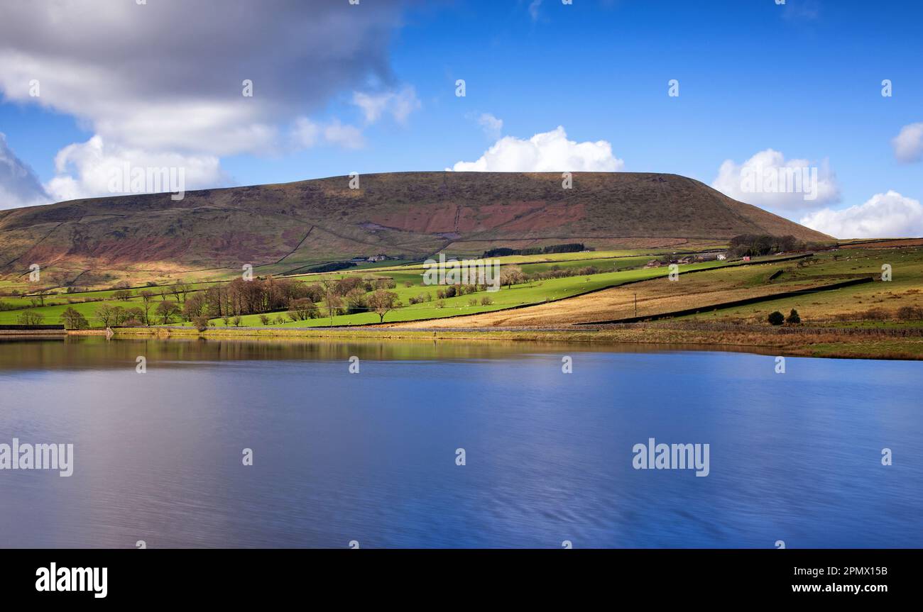 Pendle Hill visto attraverso il serbatoio di Black Moss, con una lunga esposizione che mostra una superficie appiattita Foto Stock
