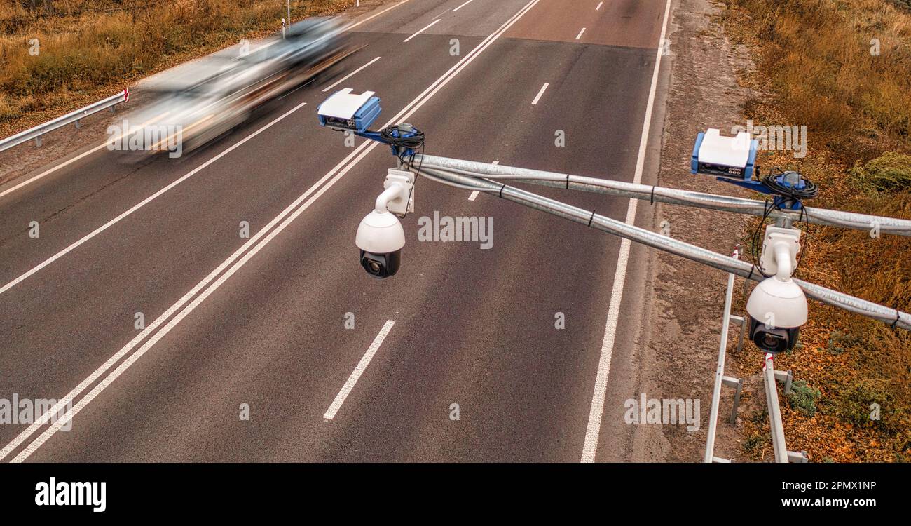 Una telecamera di monitoraggio del traffico montata in alto sopra l'autostrada cattura il movimento dei veicoli al di sotto, tenendo d'occhio la velocità del conducente per evitare accidenti Foto Stock