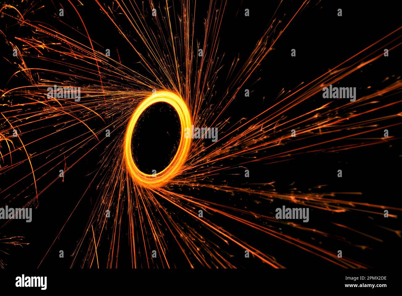 Osserva l'incantevole bellezza del cerchio dei fuochi d'artificio del bengala che splende nell'oscurità della notte Foto Stock