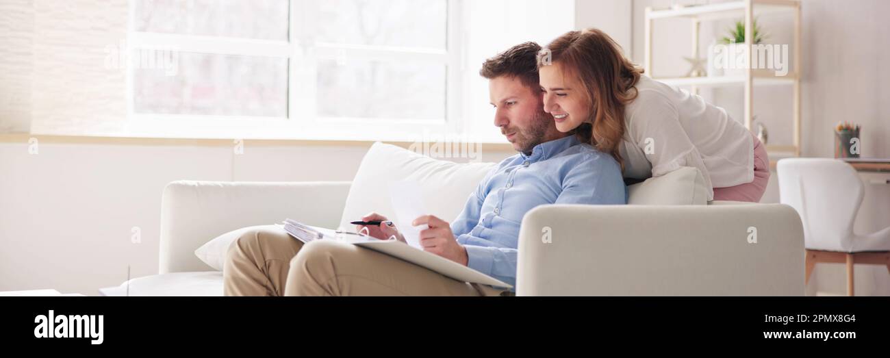 Famiglia felice che usa il calcolatore per le tasse e il preventivo Foto Stock