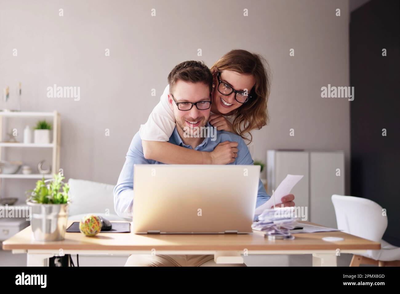 Famiglia felice che usa il calcolatore per le tasse e il preventivo Foto Stock