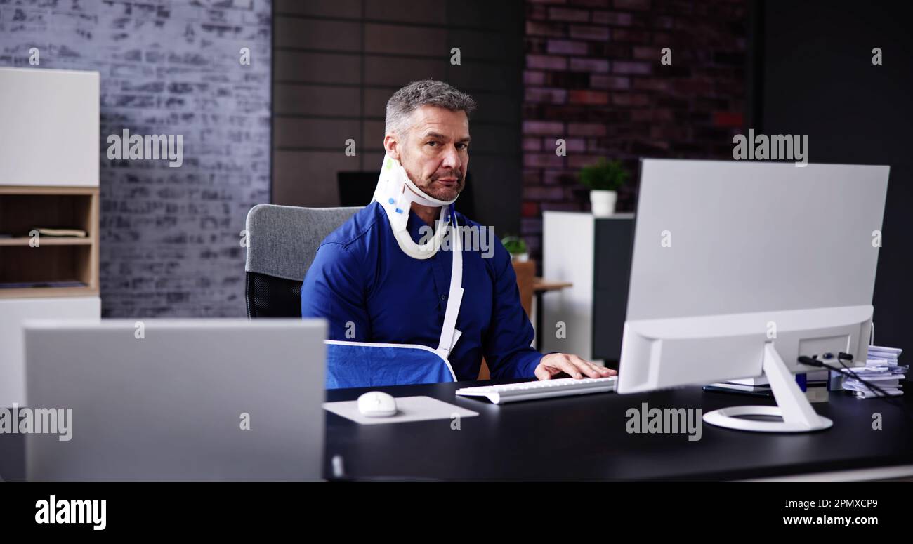 Incidente di lesione al braccio rotto. Uomo in ufficio che utilizza il computer Foto Stock